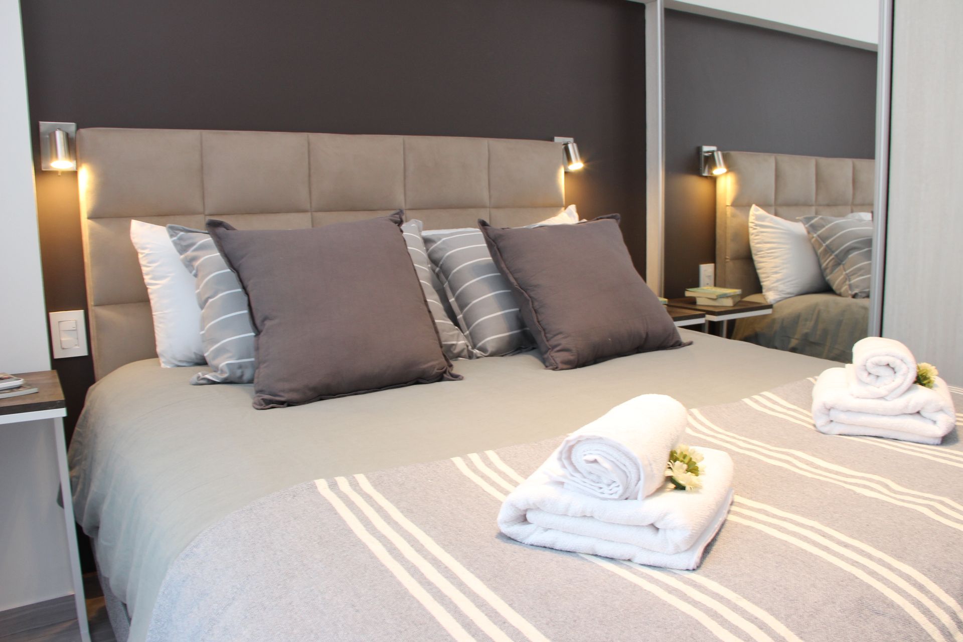 Una cama con almohadas y toallas en una habitación de hotel.