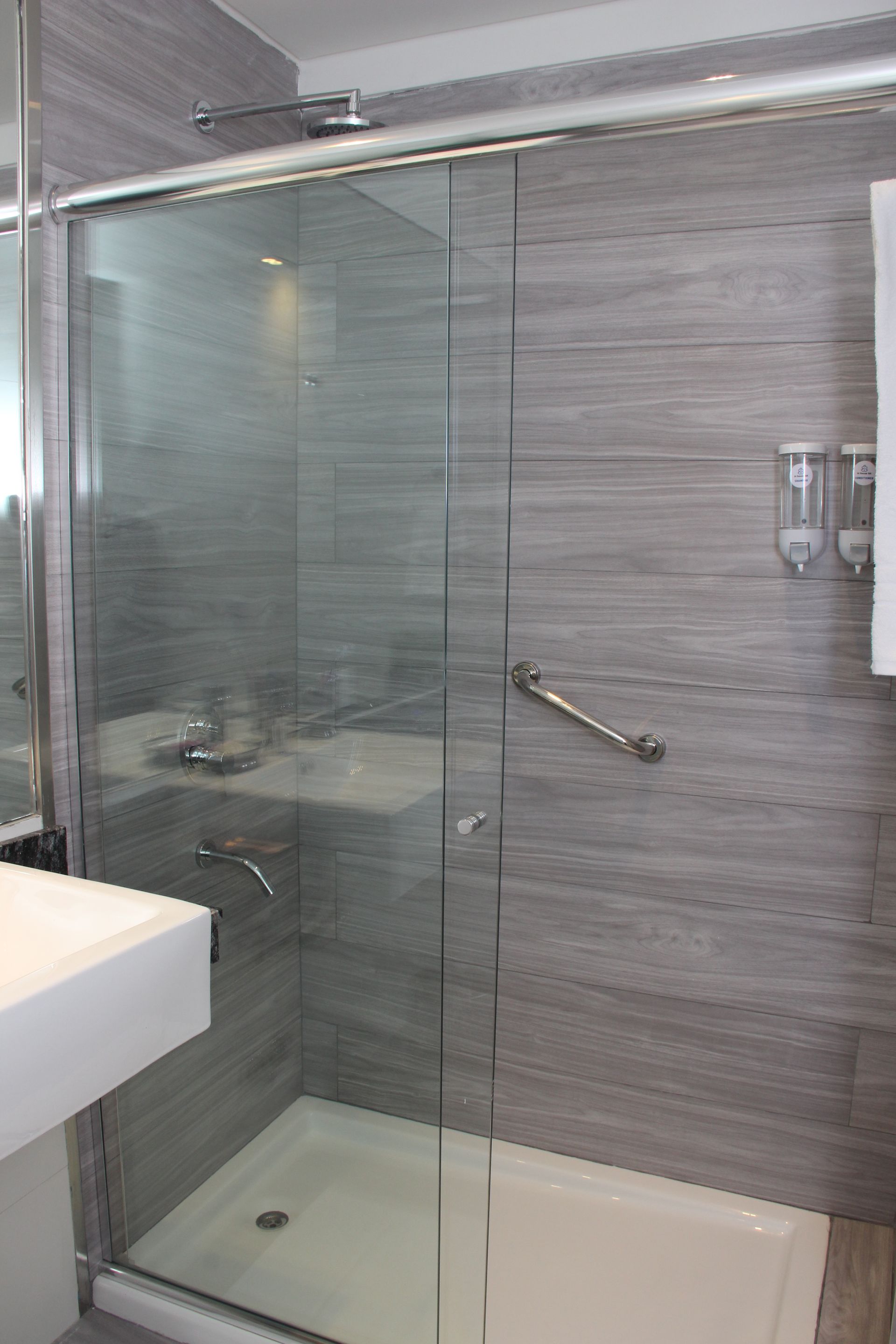 Un baño con puerta de ducha corrediza de cristal y lavabo.