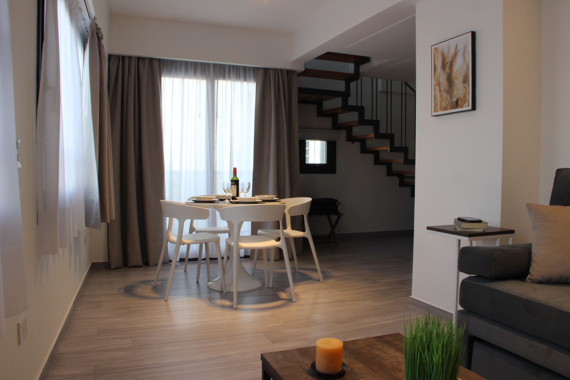 Una sala de estar con una mesa de comedor y sillas y una escalera.