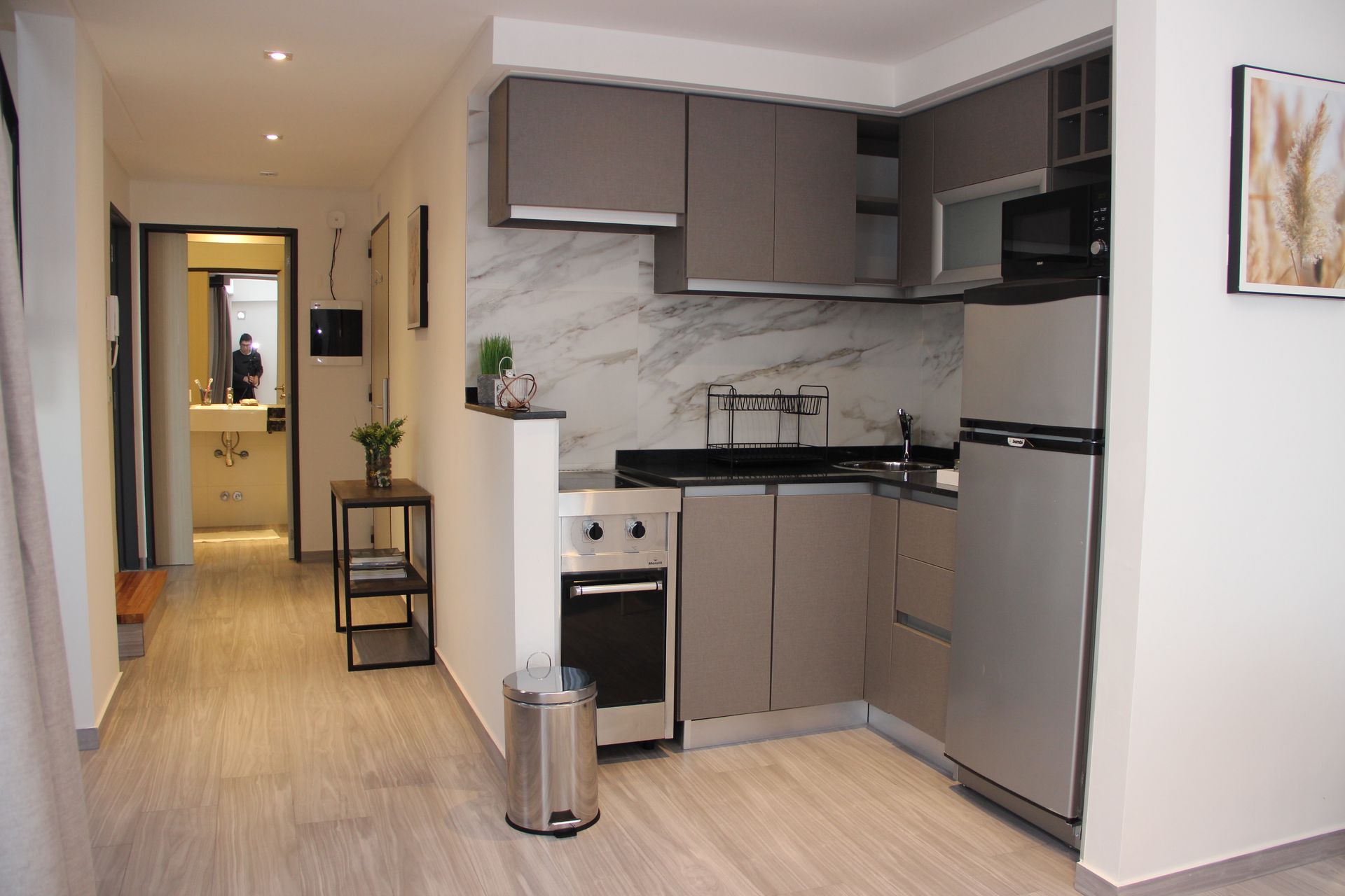 Una cocina con electrodomésticos de acero inoxidable y un bote de basura.