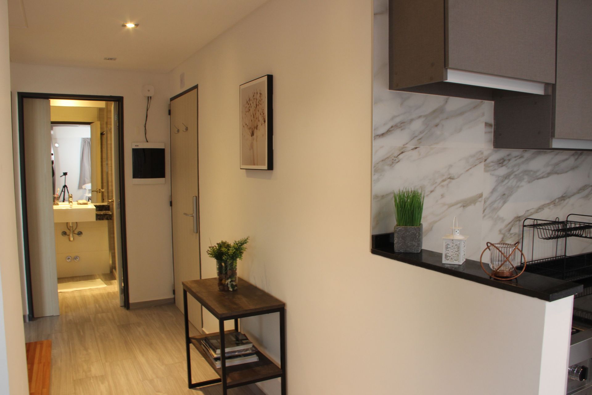 Un pasillo con una mesa en el medio y una cocina al fondo.