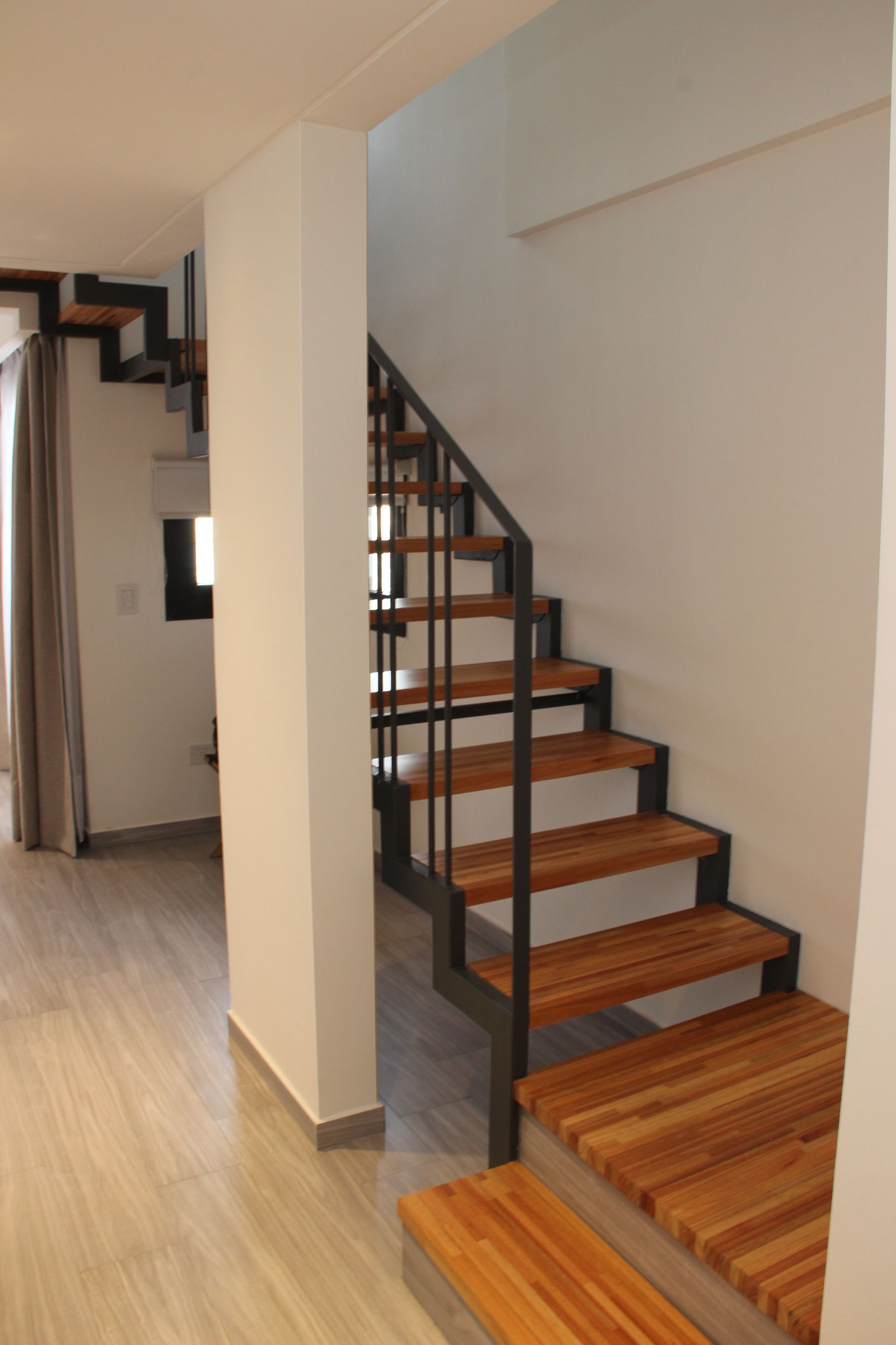 Una escalera con escalones de madera y barandilla de metal