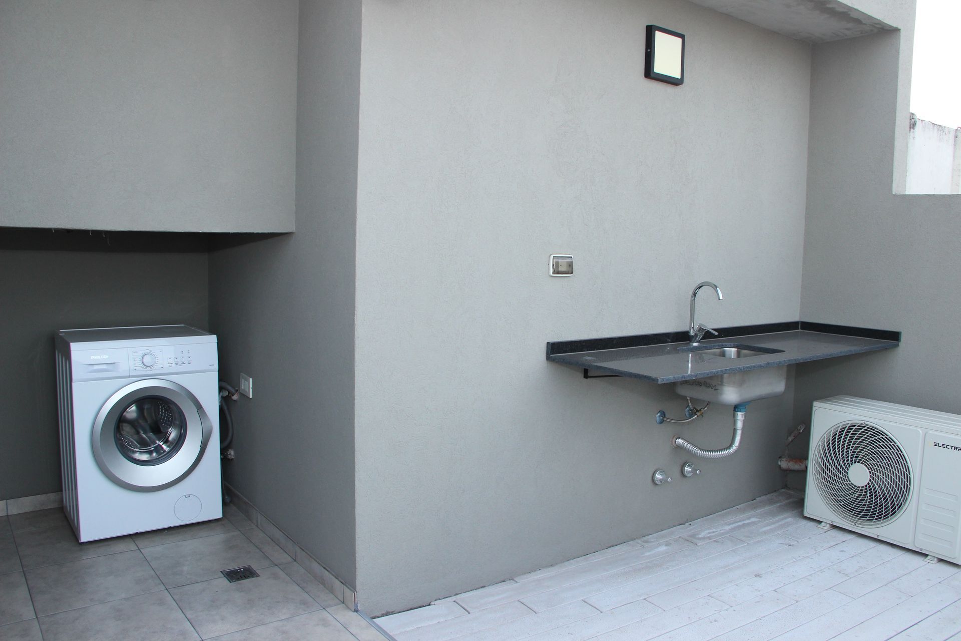 Un lavadero con lavadora, secadora y fregadero.