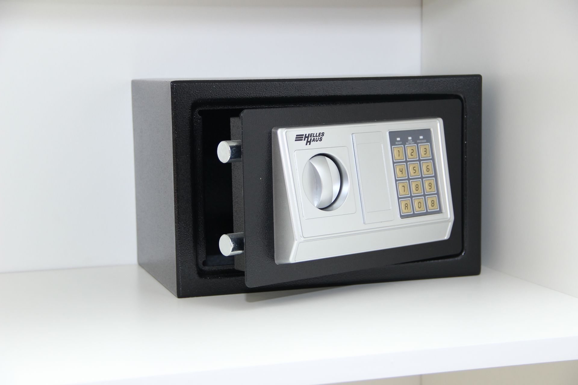 Una caja fuerte digital está colocada sobre un estante blanco.