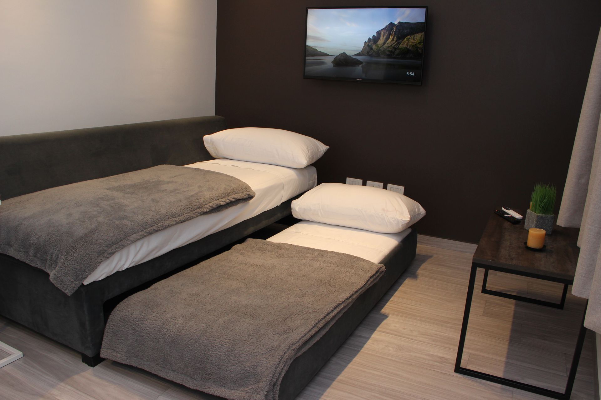 Un dormitorio con dos camas y un televisor de pantalla plana.