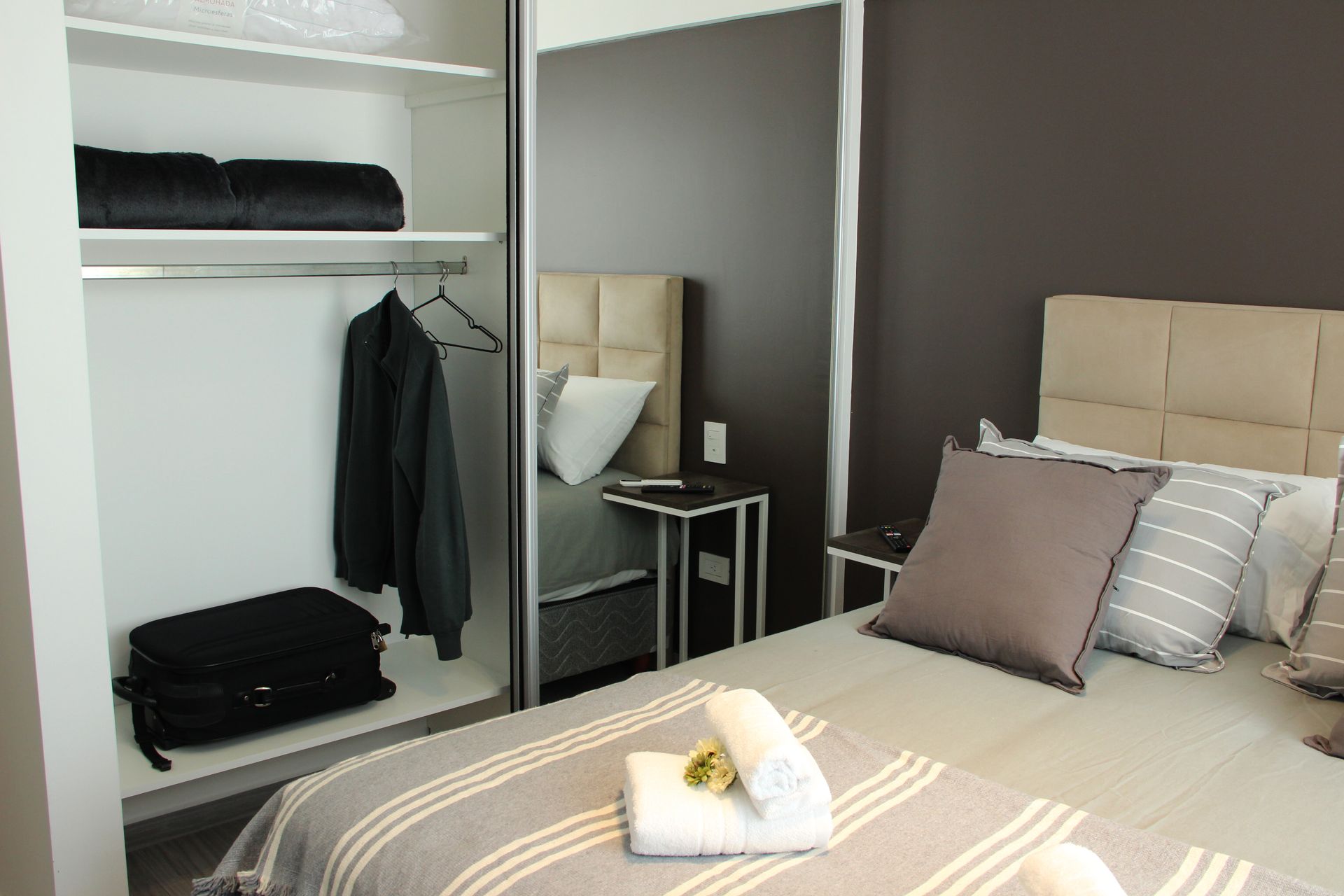 Un dormitorio con una cama y un armario con una maleta dentro.