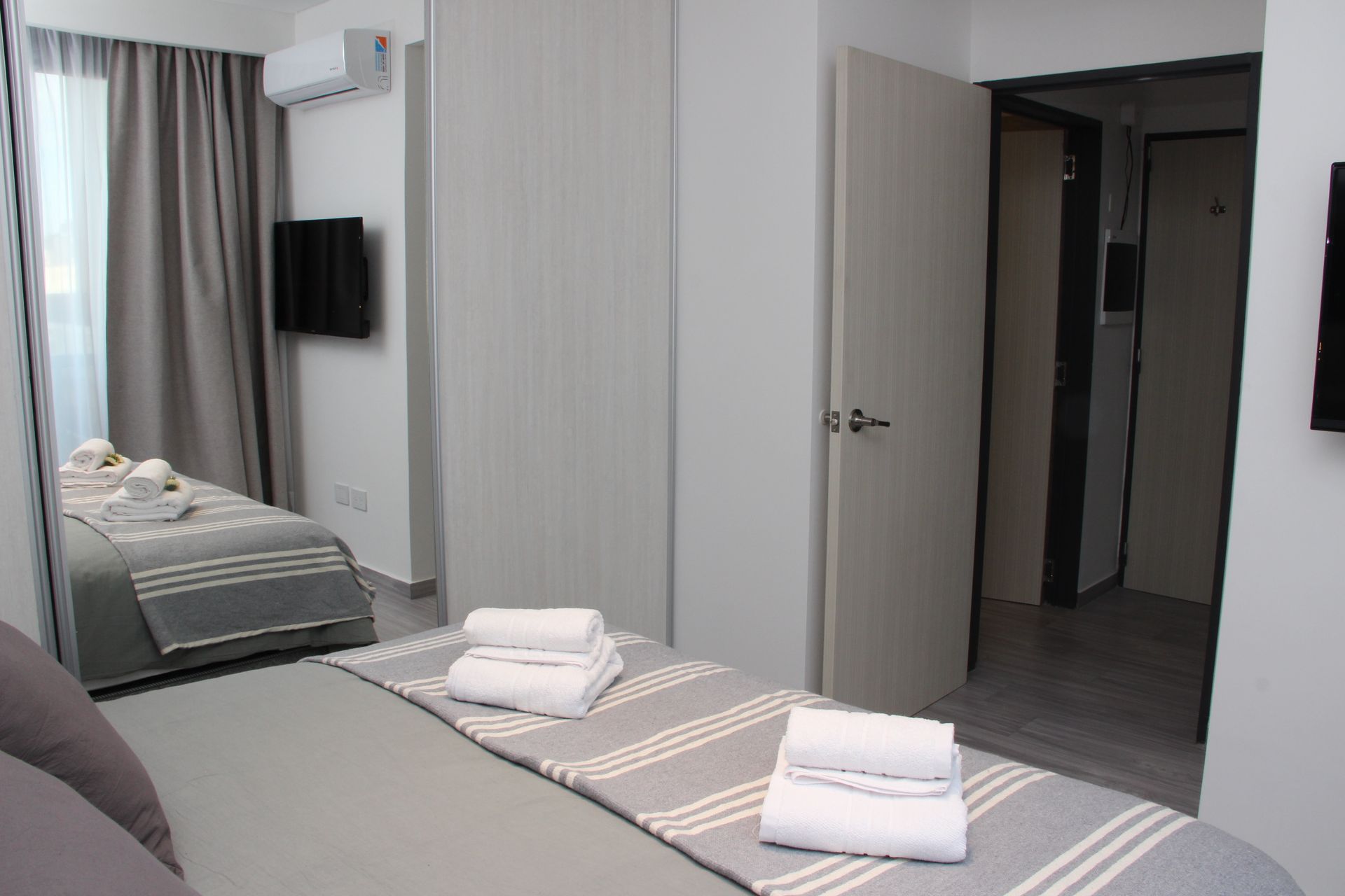 Un dormitorio con una cama king size y un espejo grande.