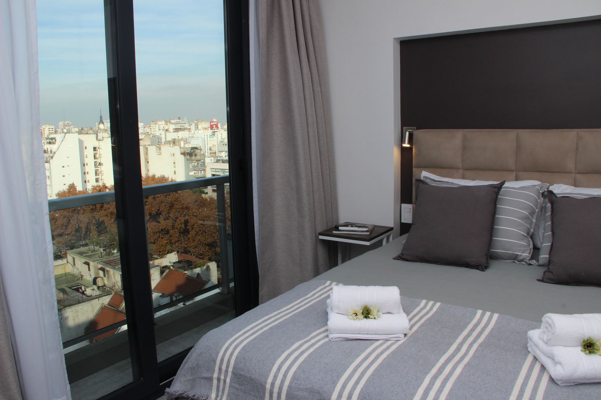 Una habitación de hotel con una cama grande y un balcón.