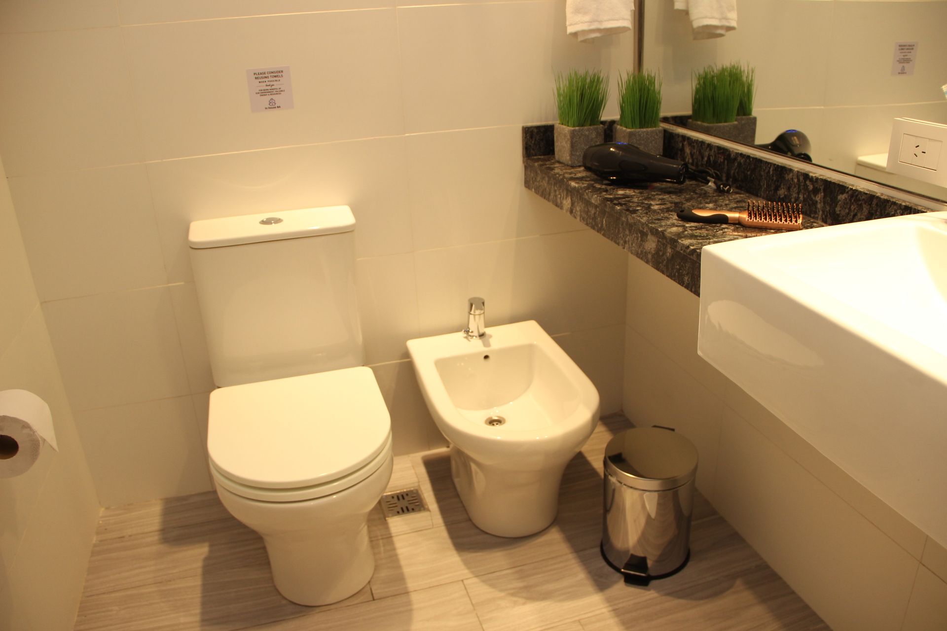 Un baño con inodoro, bidé y lavabo