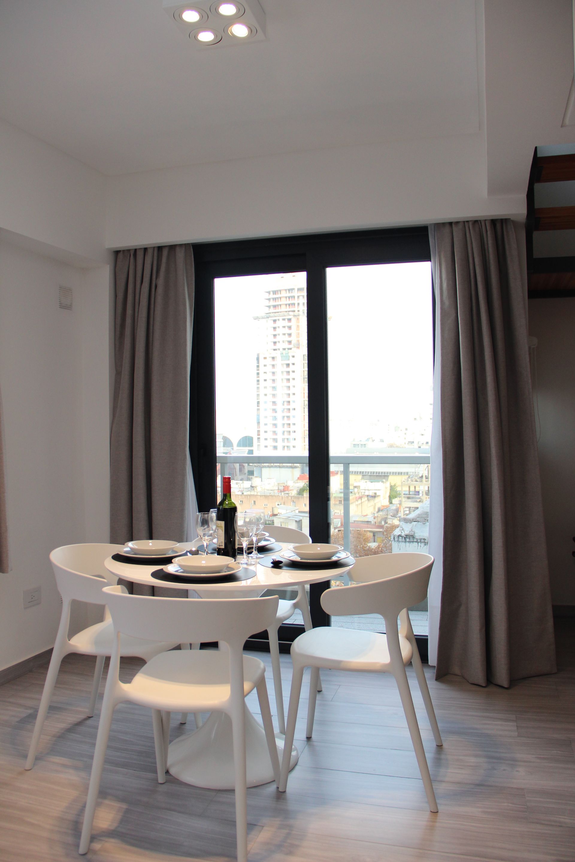 Un comedor con una mesa y sillas y una botella de vino.