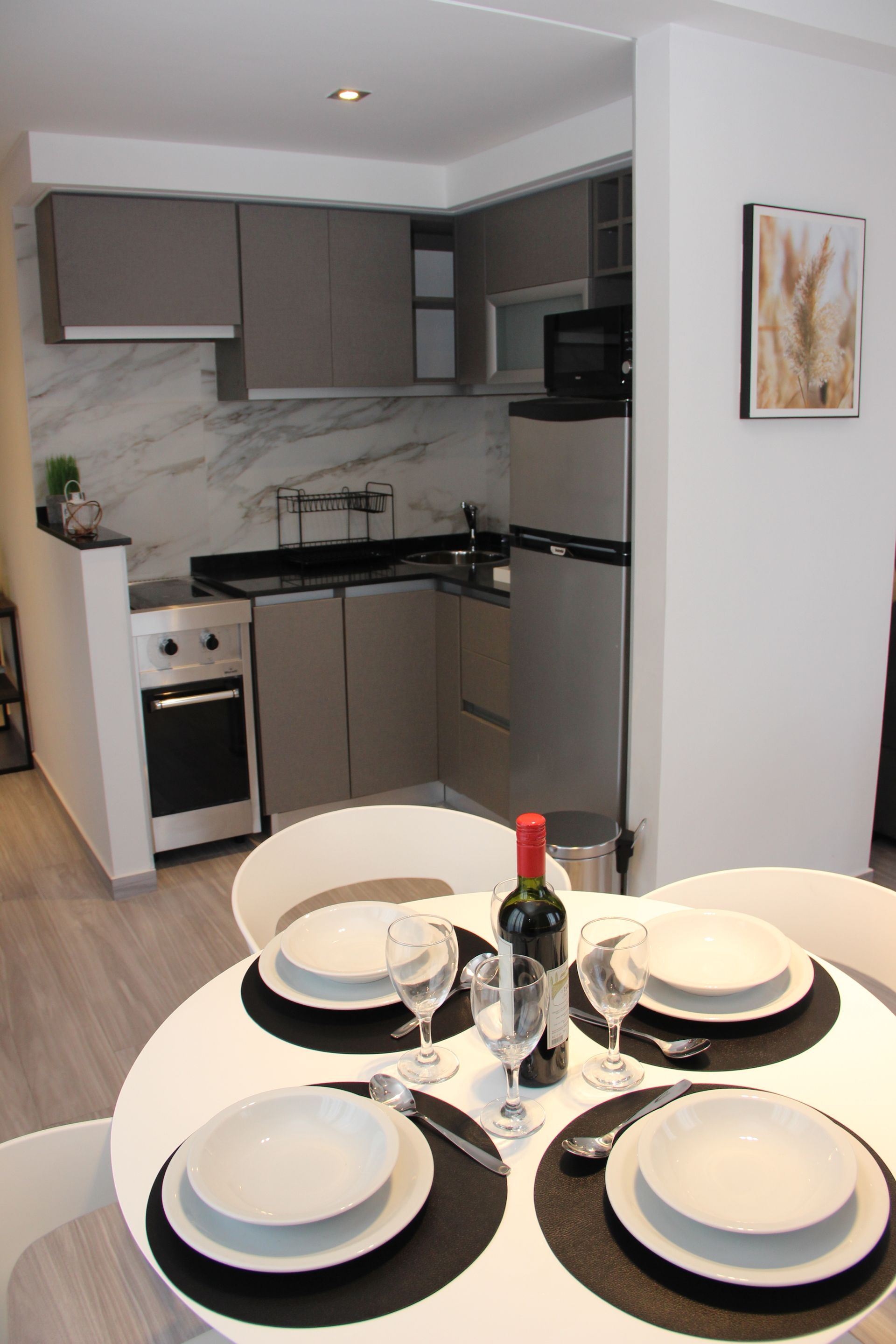 Una mesa de comedor con platos y una botella de vino.