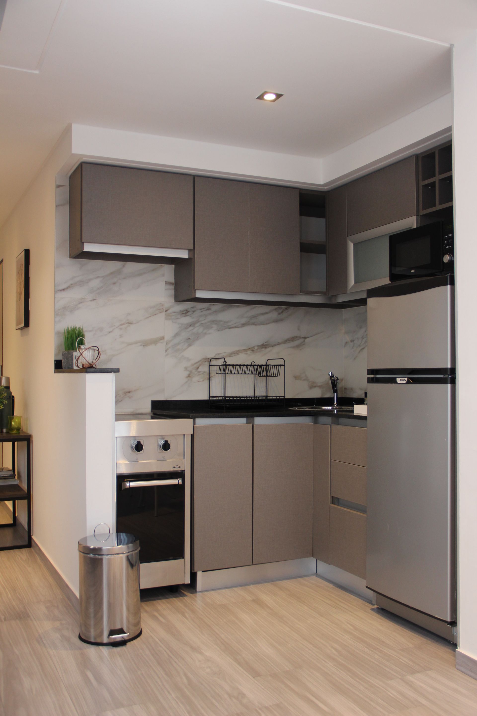 Una cocina con electrodomésticos de acero inoxidable y un bote de basura.