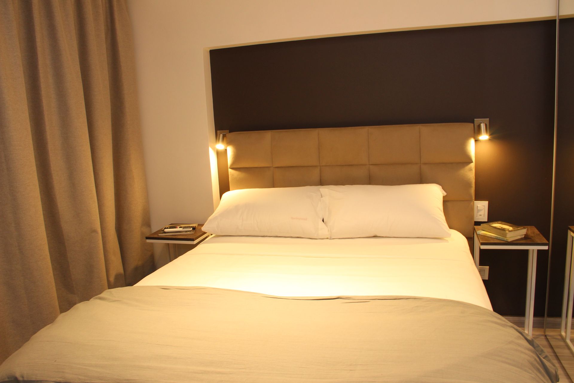 Una habitación de hotel con una cama y una mesita de noche