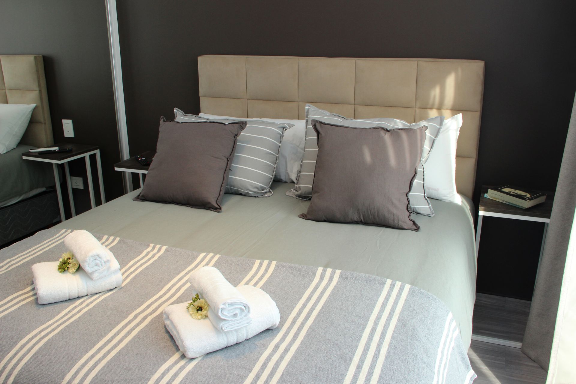 Una cama con almohadas y toallas en una habitación de hotel.