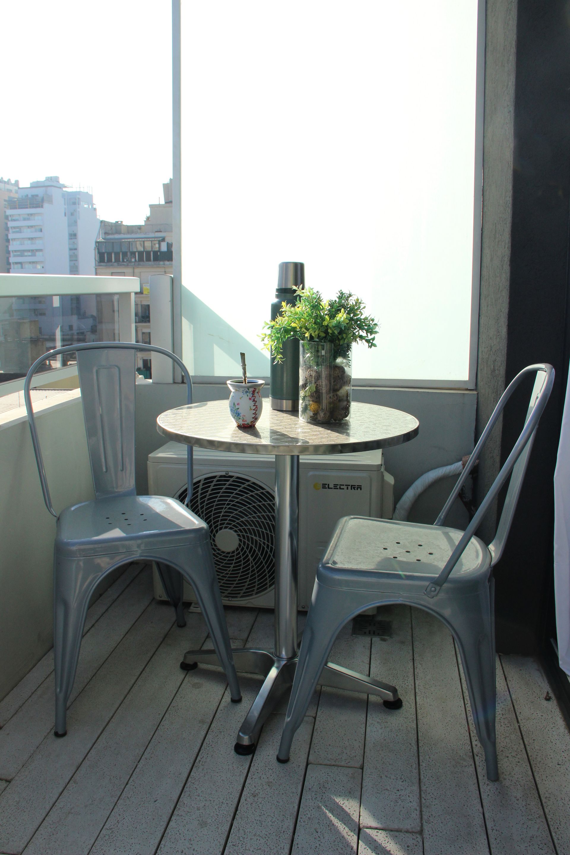 Hay una mesa y sillas en el balcón.