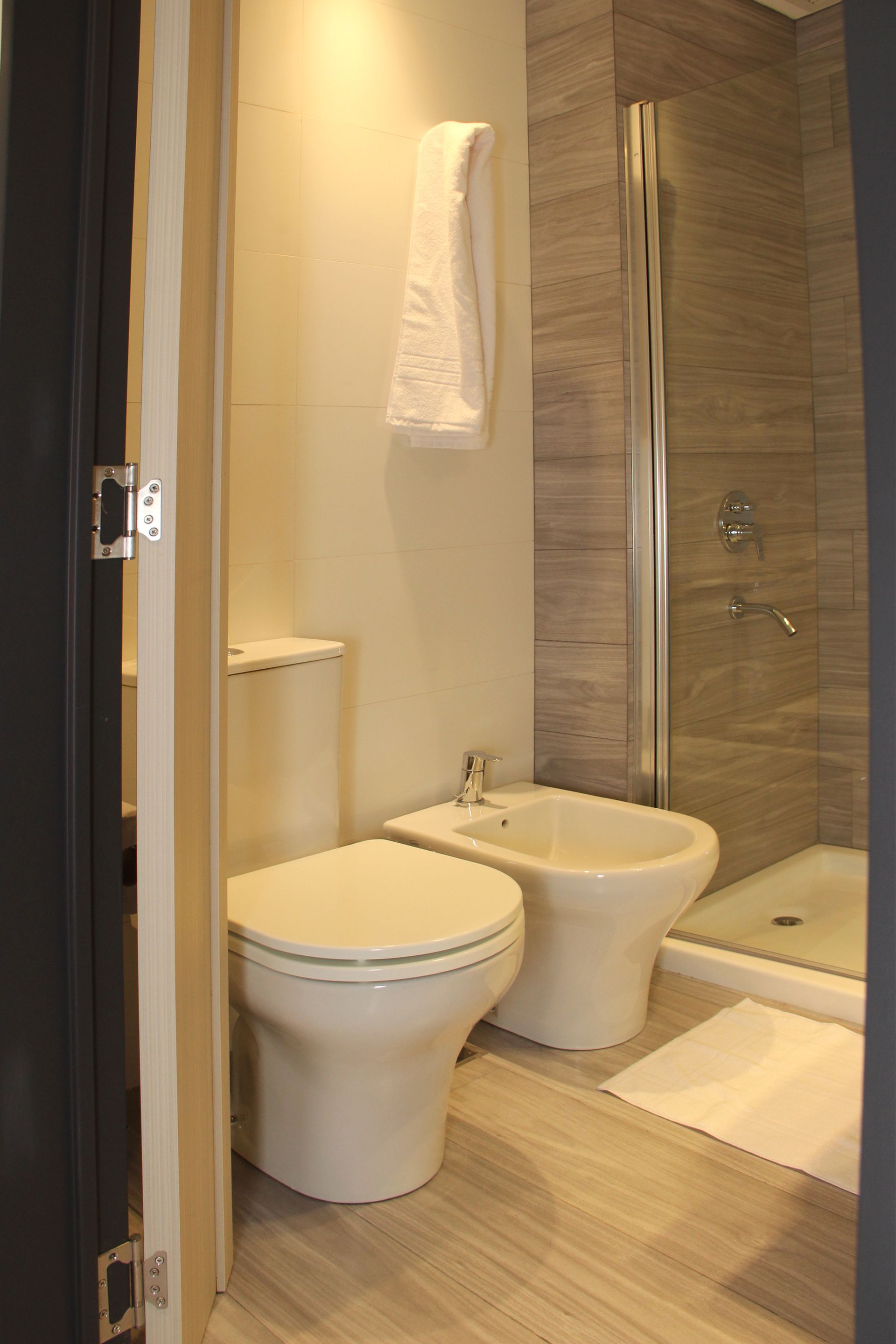 Un baño con inodoro, bidet y ducha.