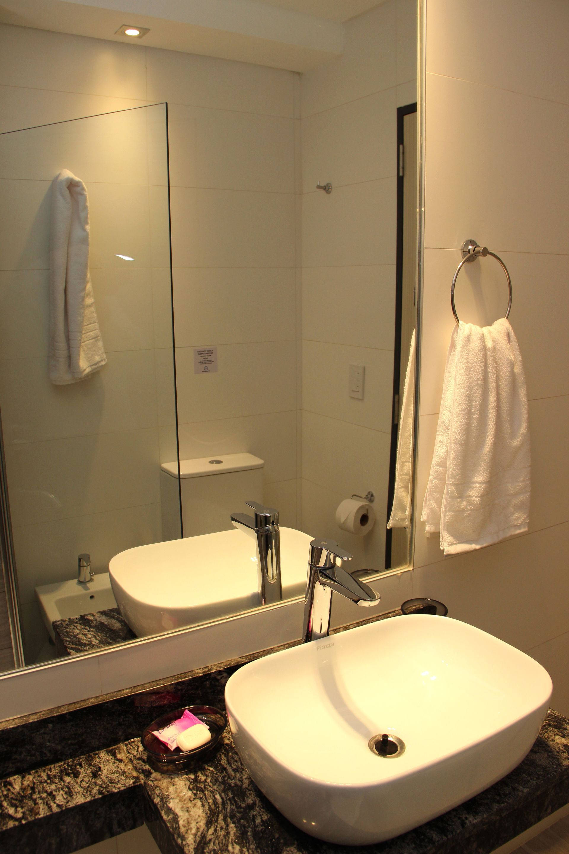 Un baño con dos lavabos y un espejo grande.