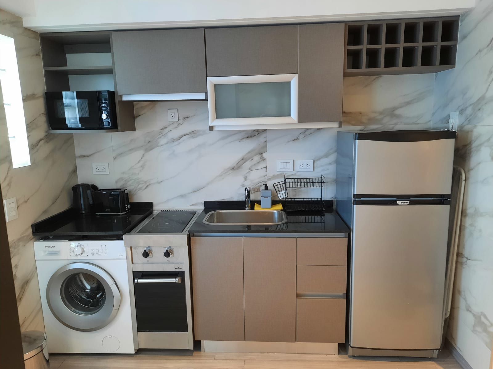 Una cocina con refrigerador, lavadora y secadora