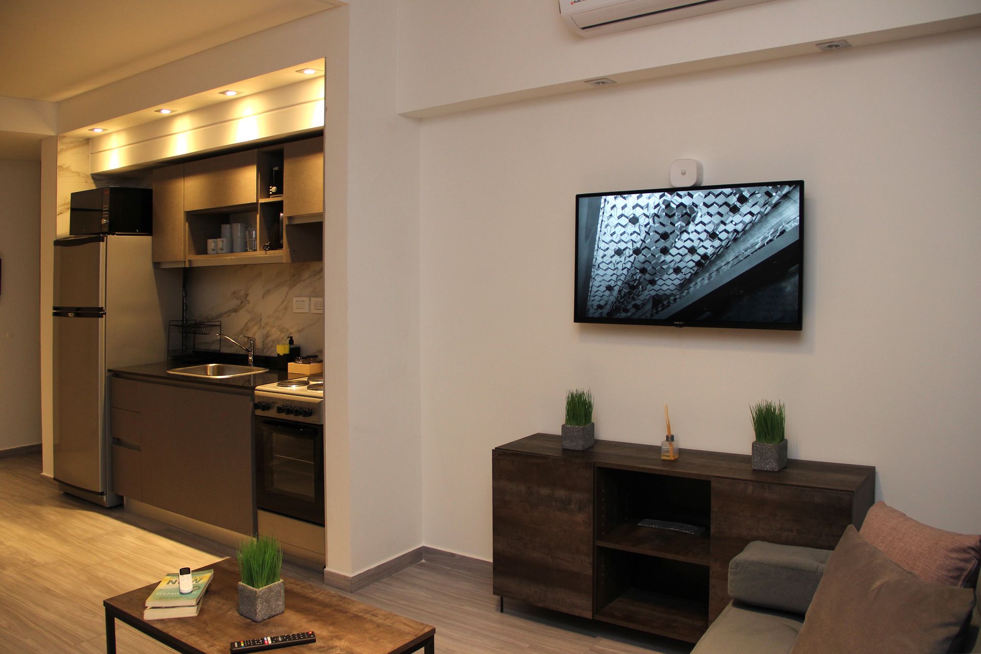 Una sala de estar con un sofá y un televisor de pantalla plana en la pared.