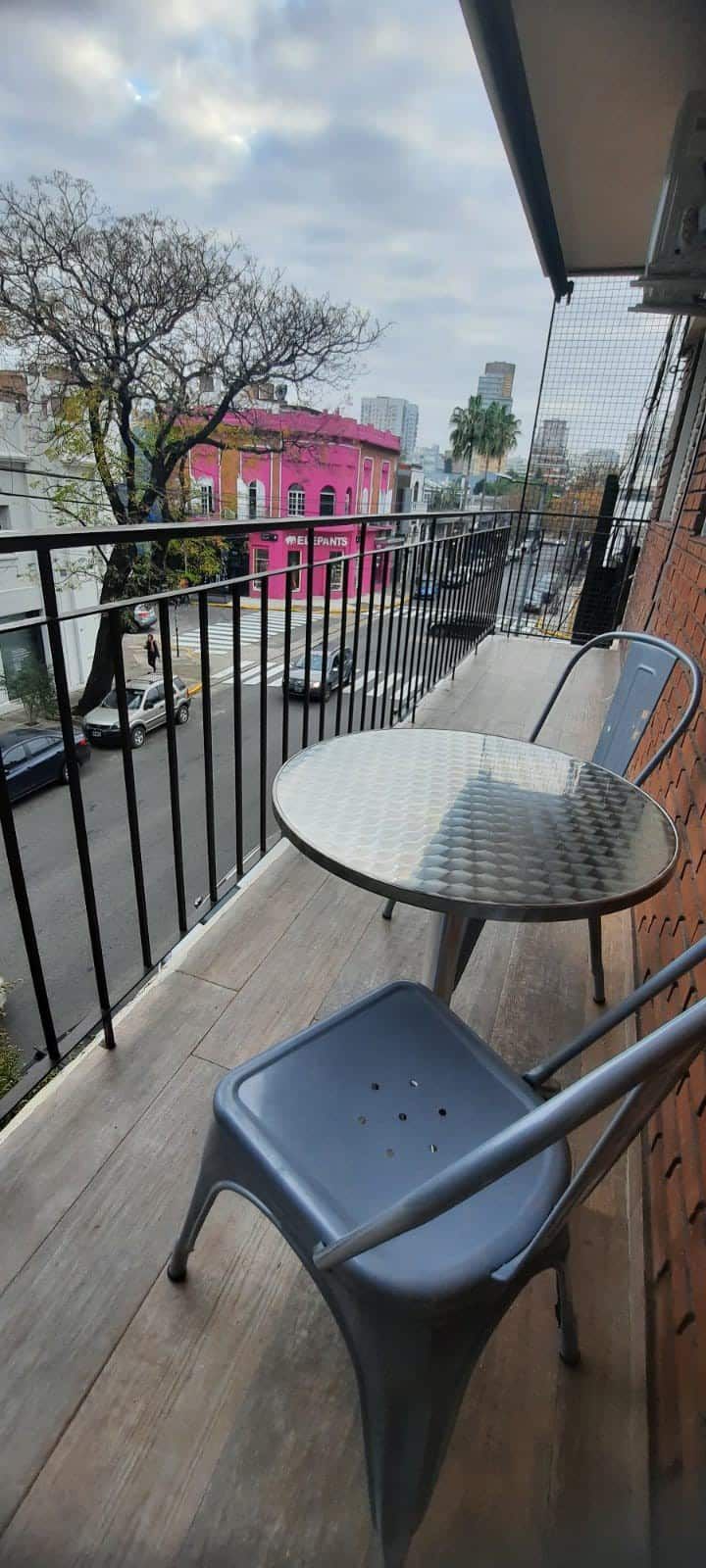 Un balcón con mesa y sillas y vista a la ciudad.