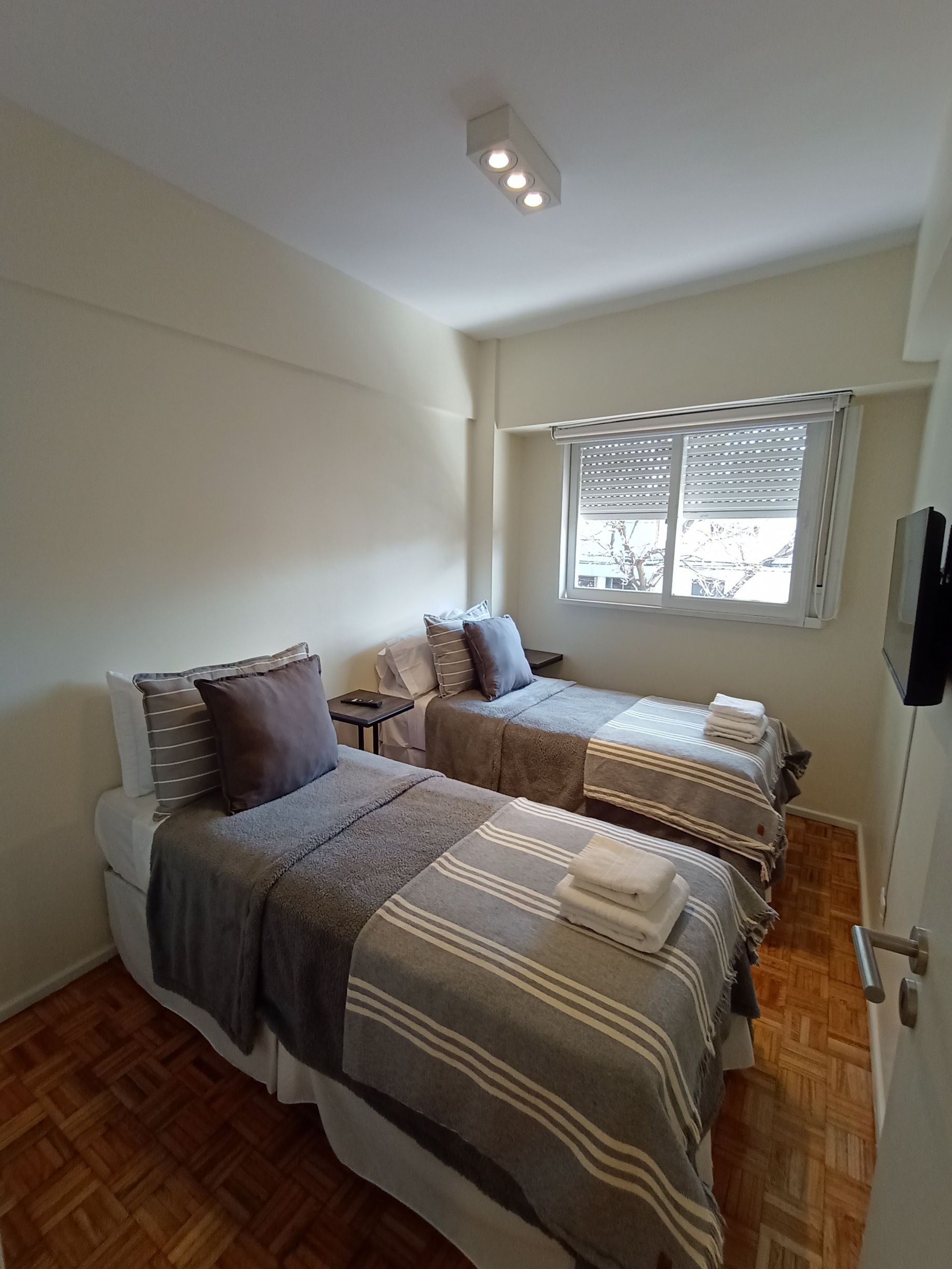 Un dormitorio con dos camas individuales y televisión.