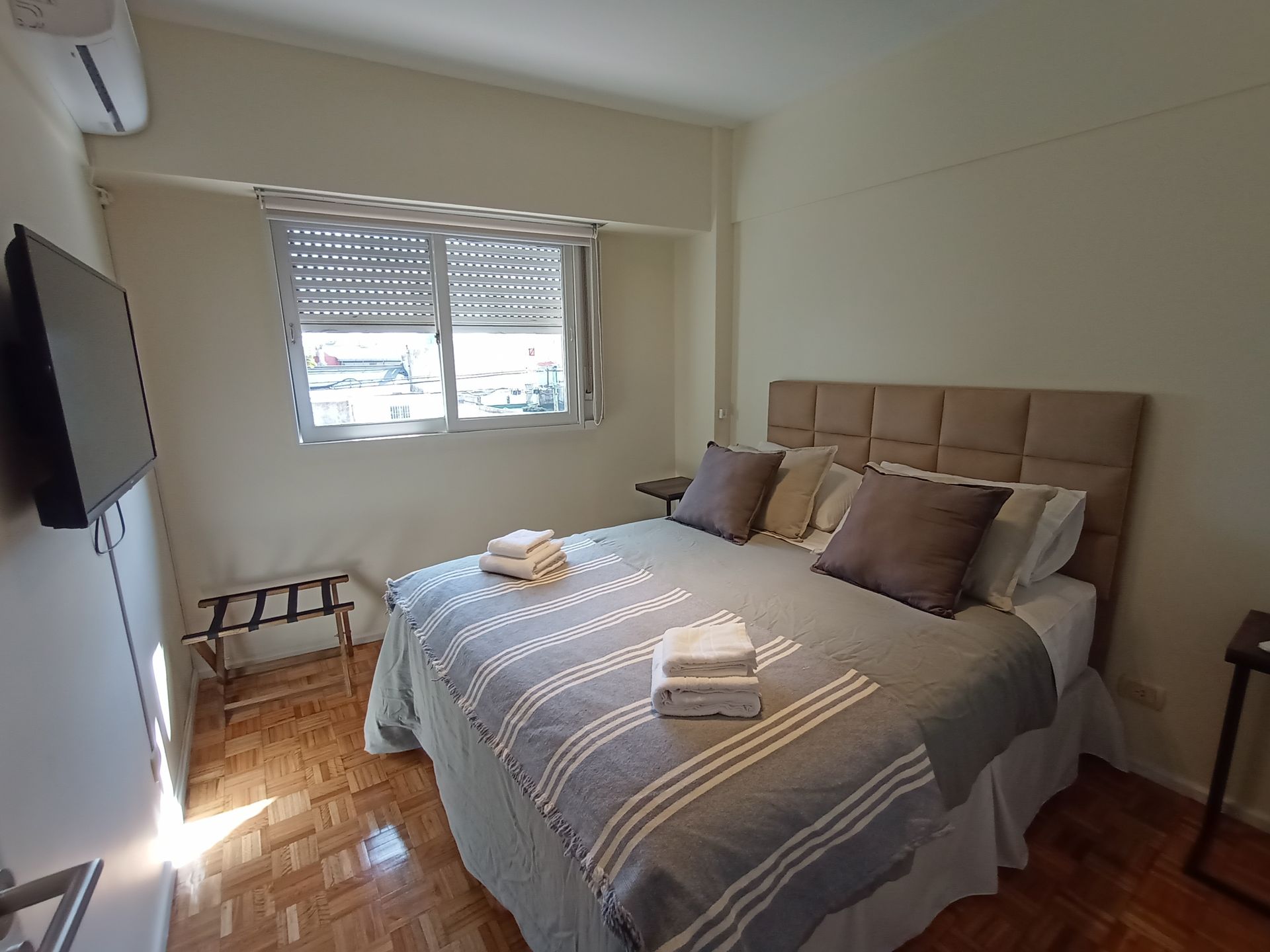 Un dormitorio con una cama grande y un televisor de pantalla plana.