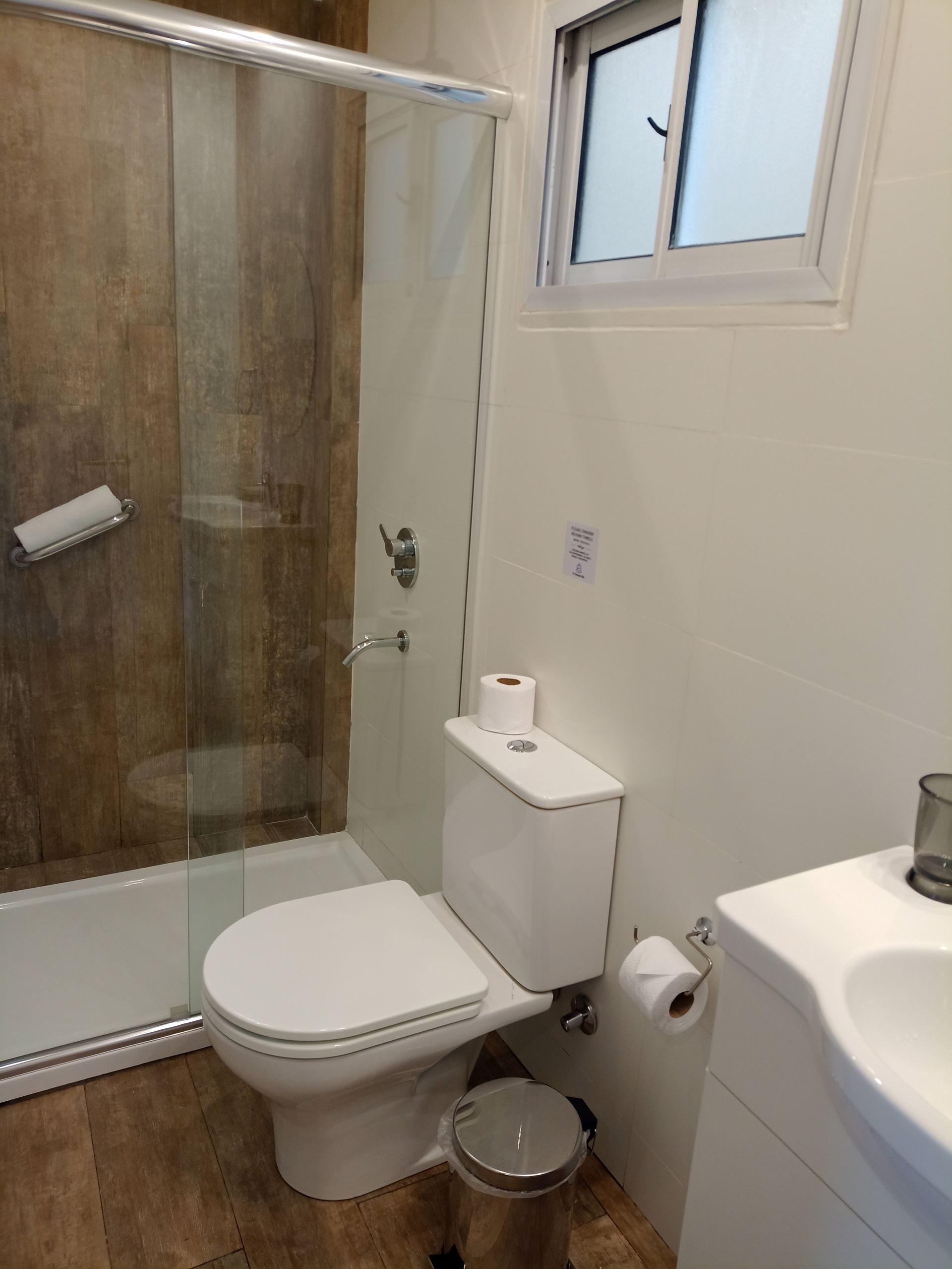 Un baño con inodoro, lavabo y ducha.