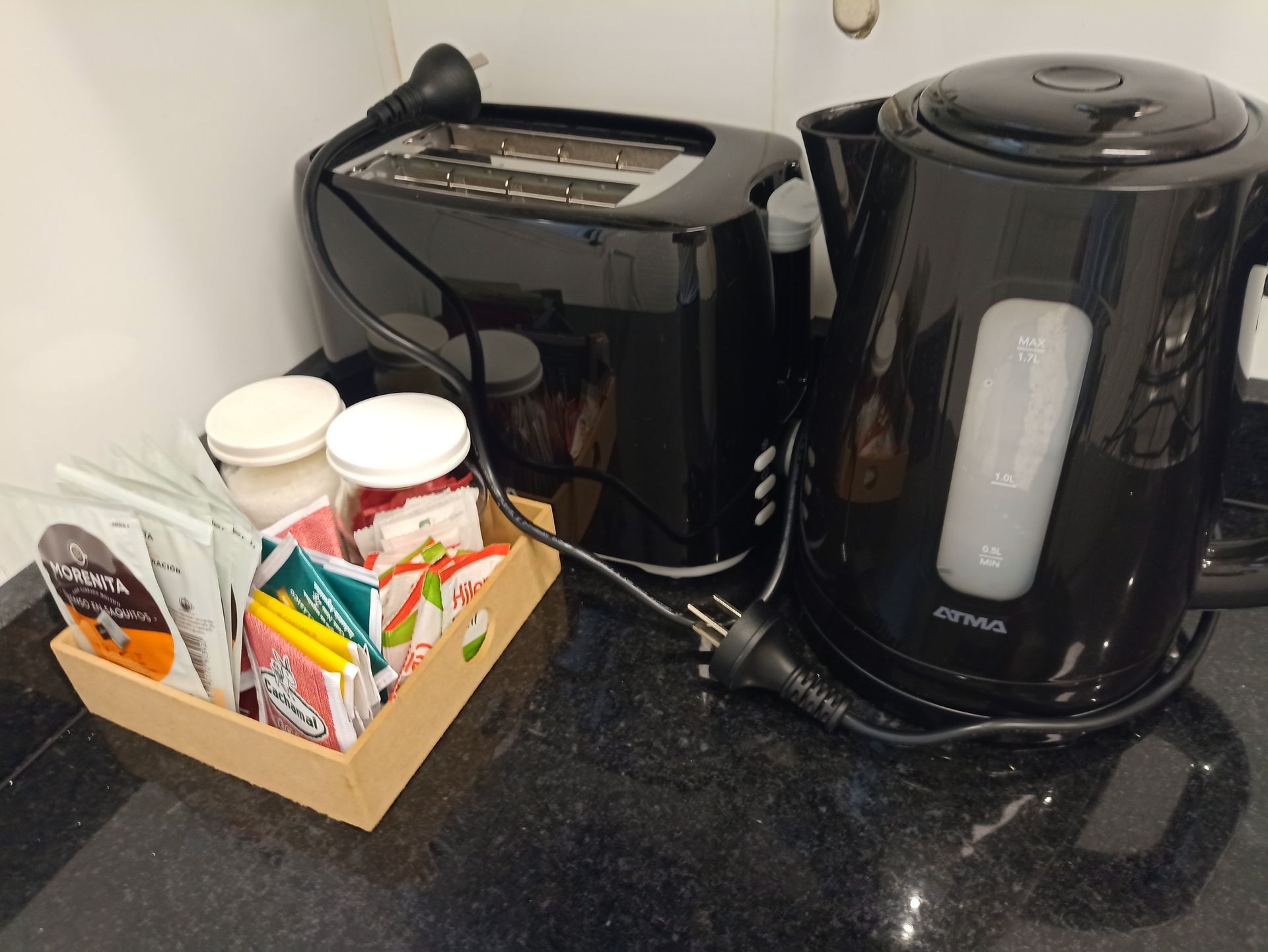 Una encimera de cocina con una tostadora y una tetera.