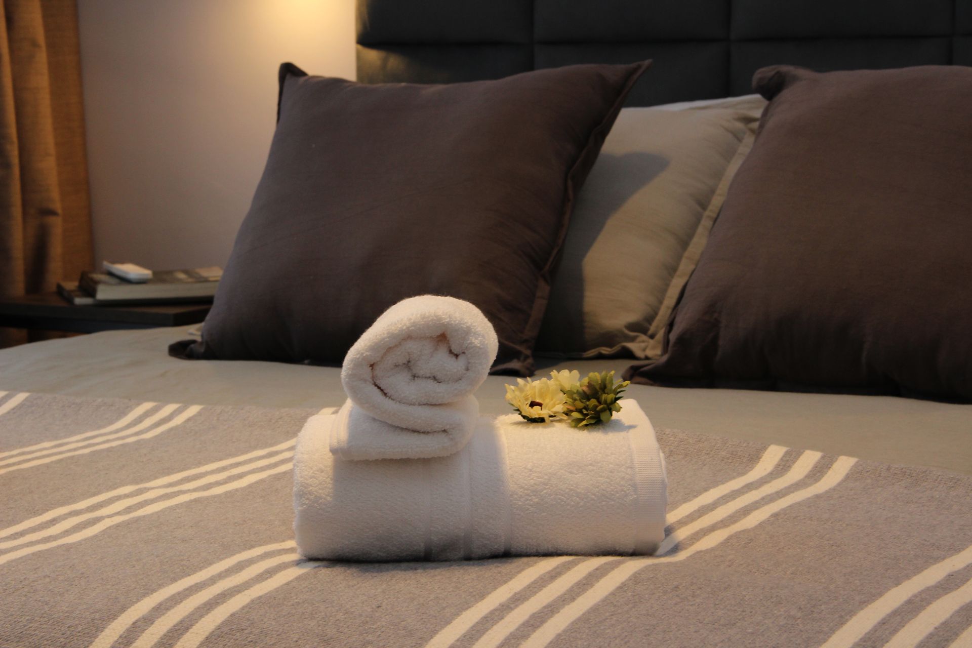 Una cama con almohadas y toallas encima