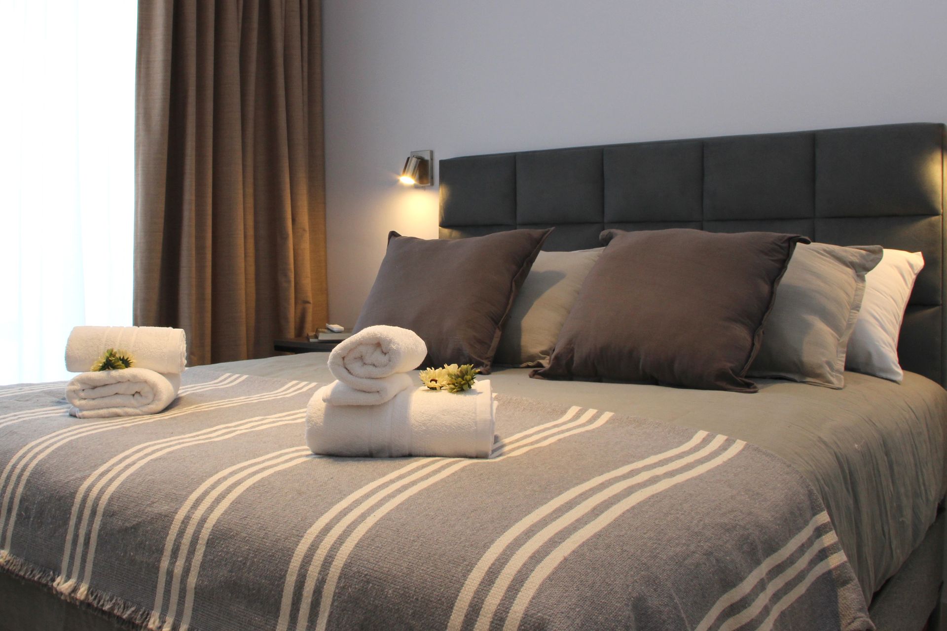 Una cama con toallas y almohadas en una habitación de hotel.