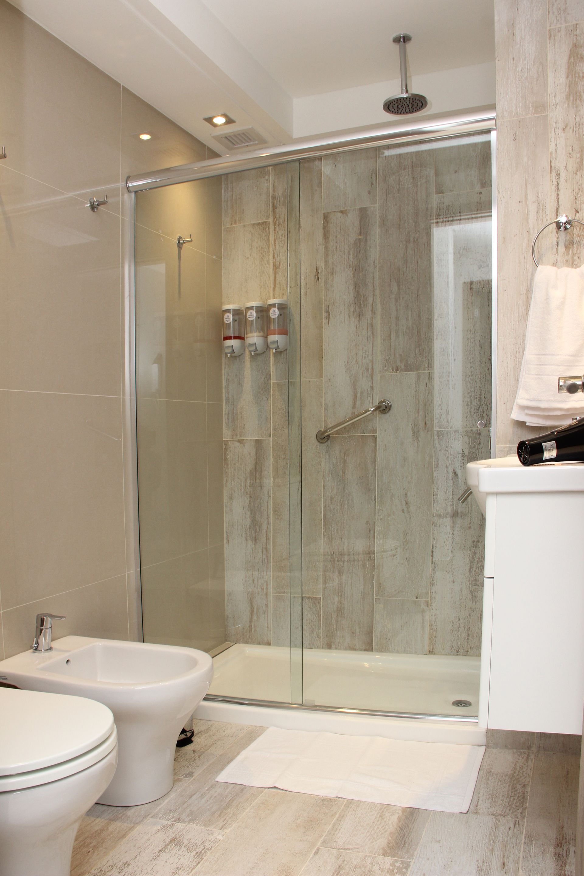 Un baño con inodoro, bidet y ducha.