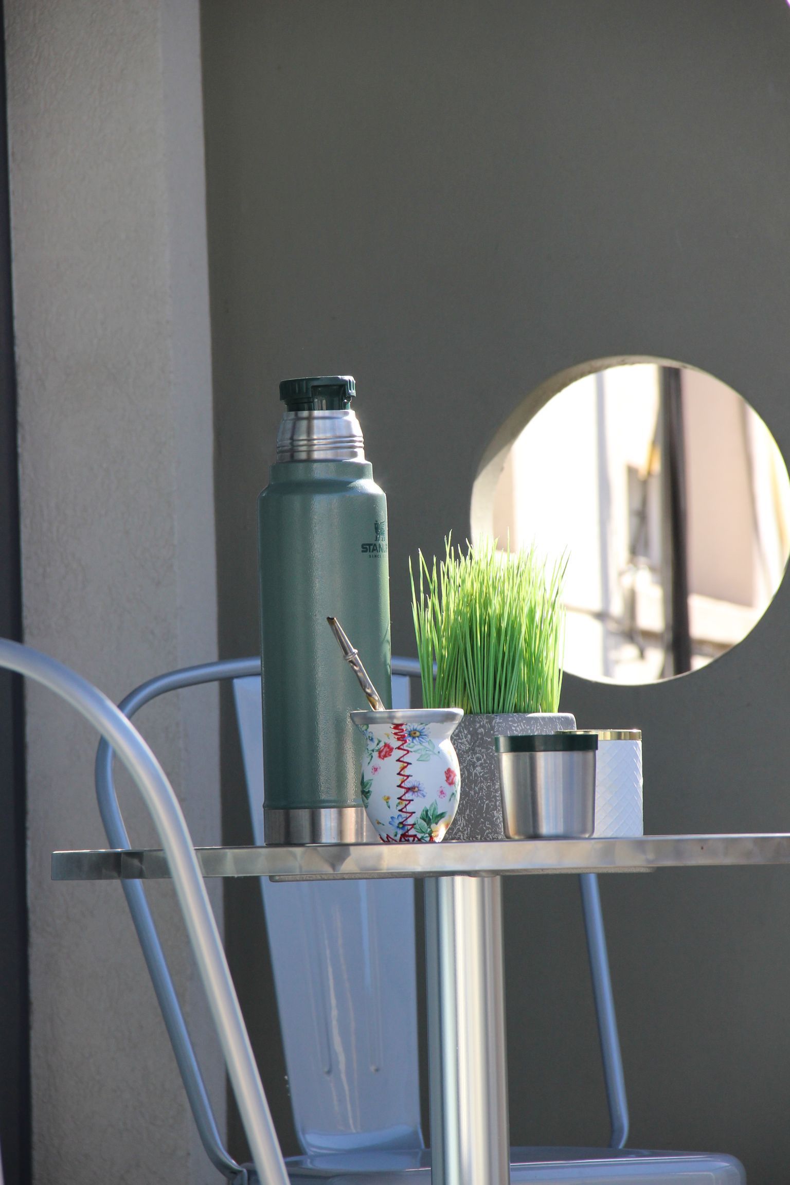 Una mesa con una botella y una taza encima.