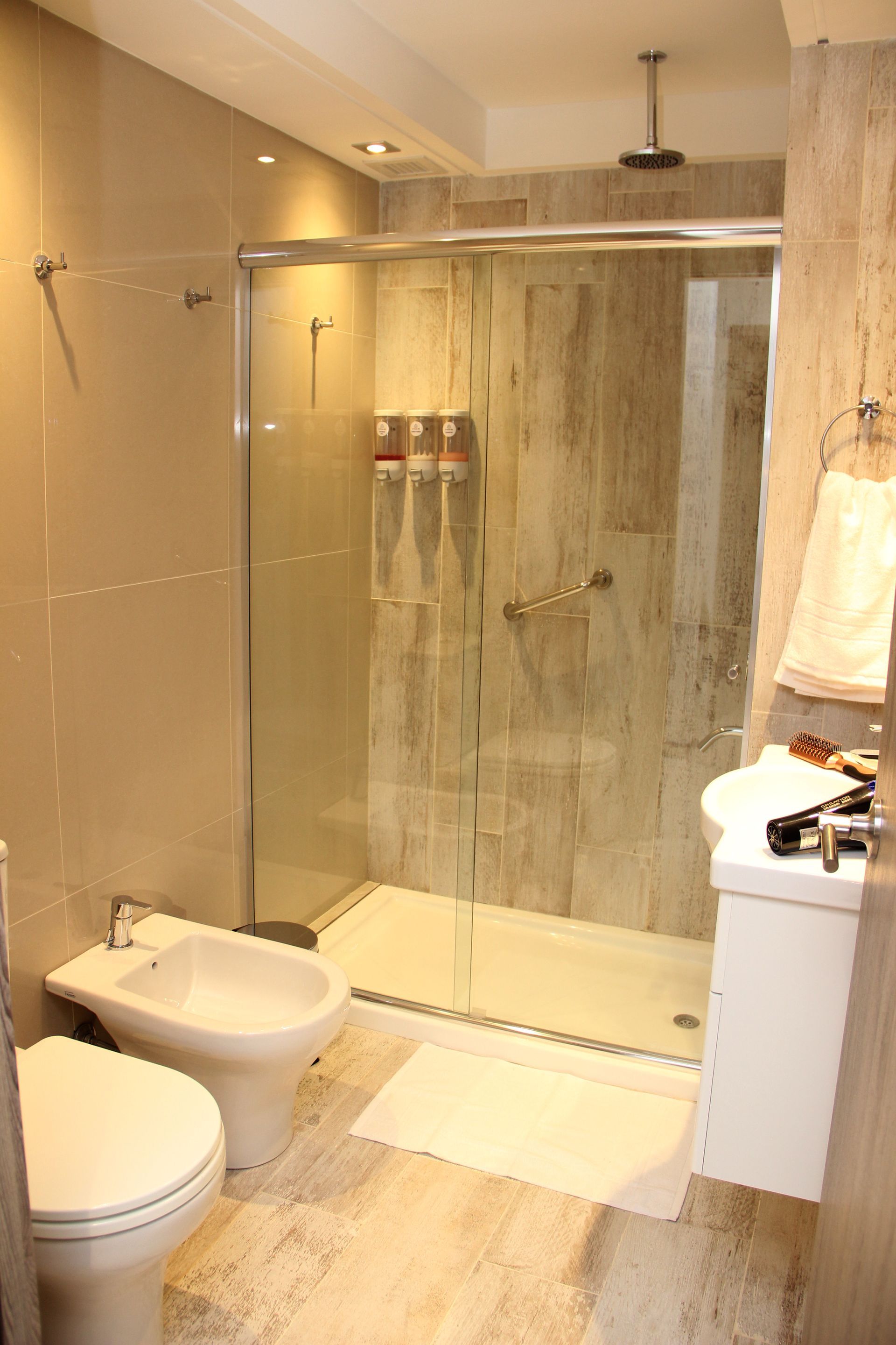 Un baño con inodoro, bidet, lavabo y ducha.