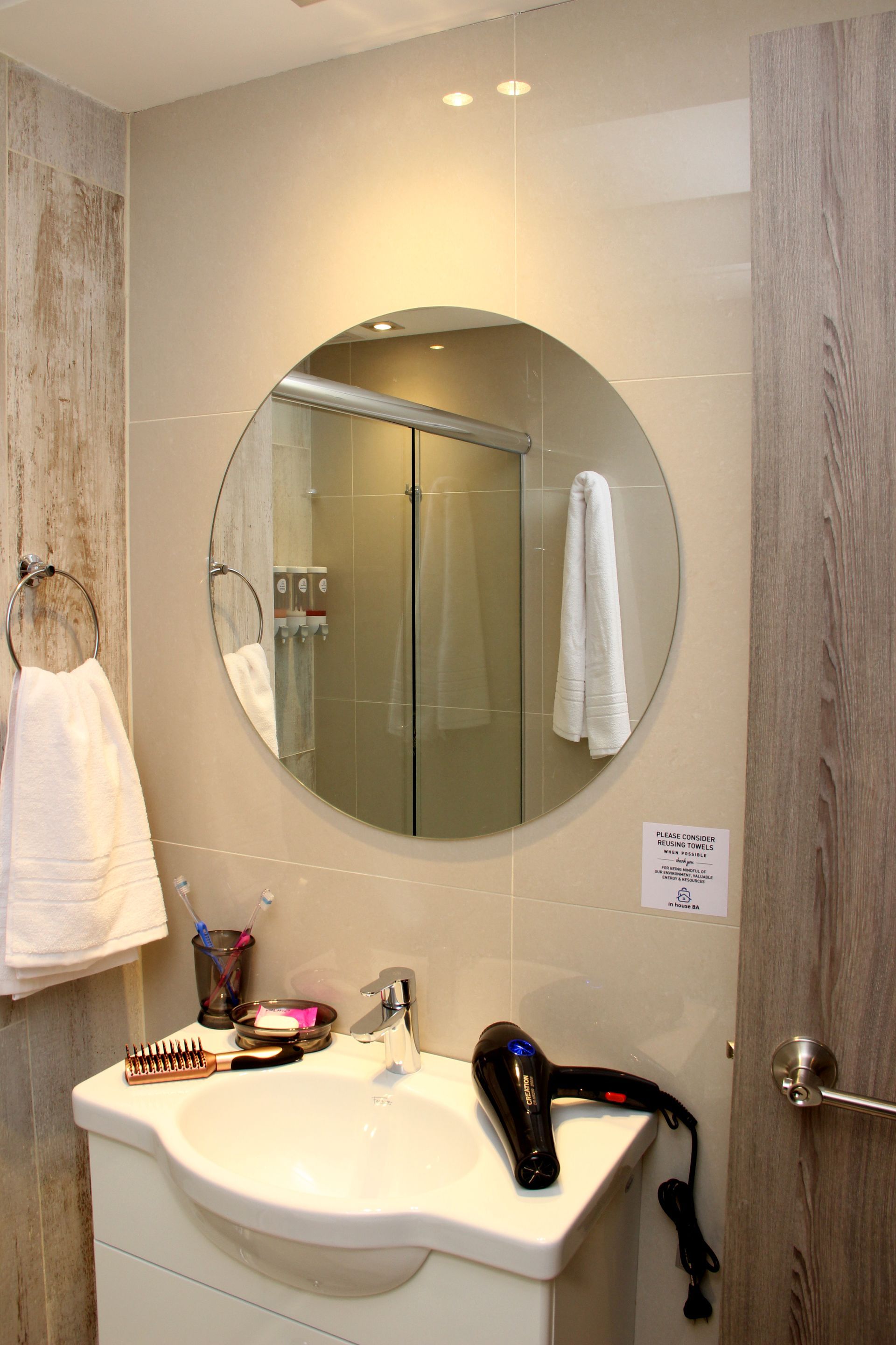 Un baño con lavabo, espejo y secador de pelo.