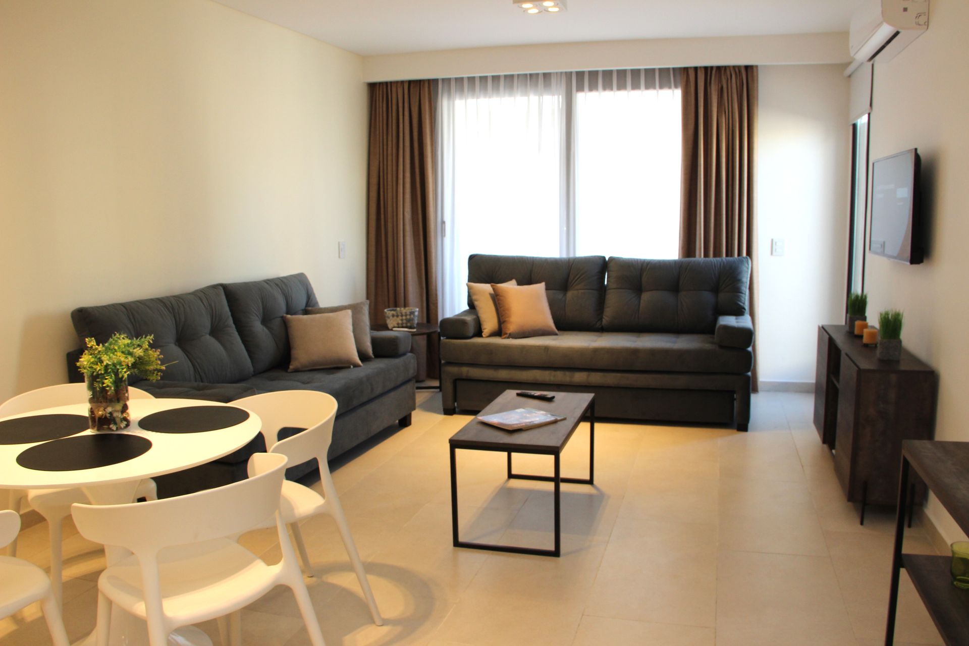 Una sala de estar con sofá, mesa y sillas.