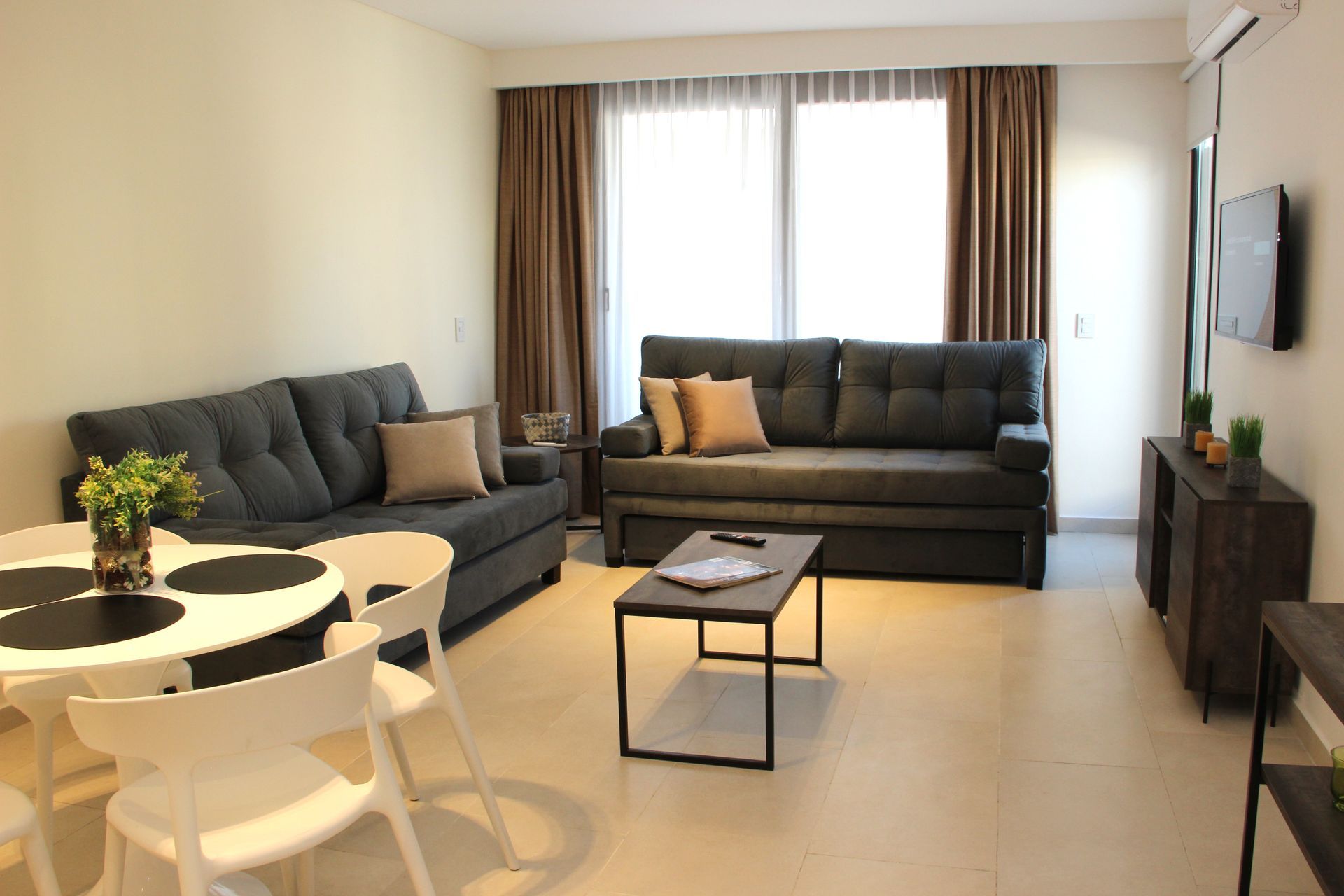 Una sala de estar con sofá, mesa y sillas.