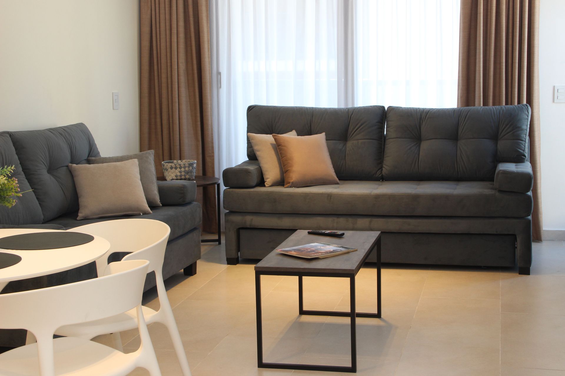 Una sala de estar con sofá, mesa y sillas.