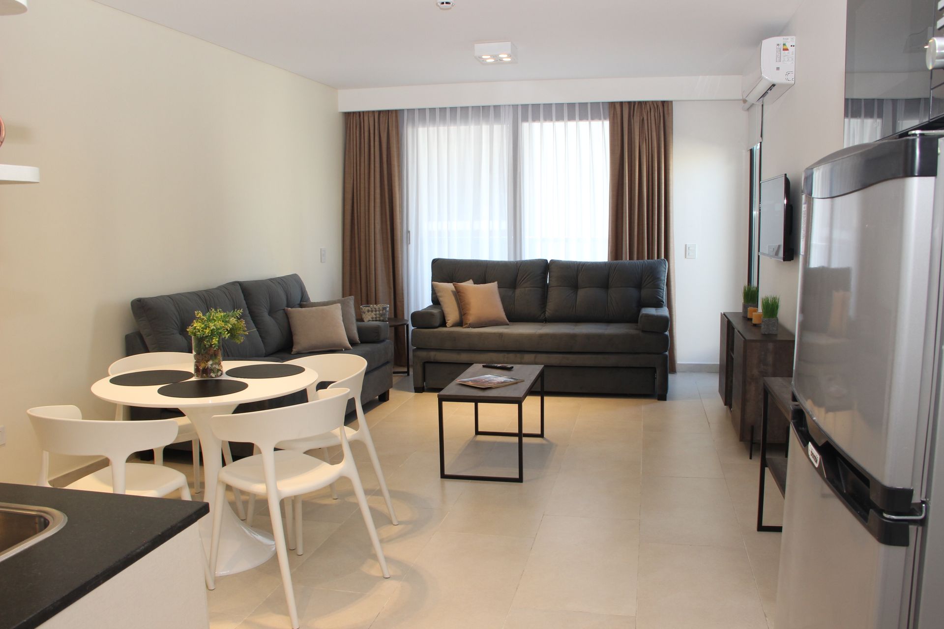 Una sala de estar con sofá, mesa y sillas.