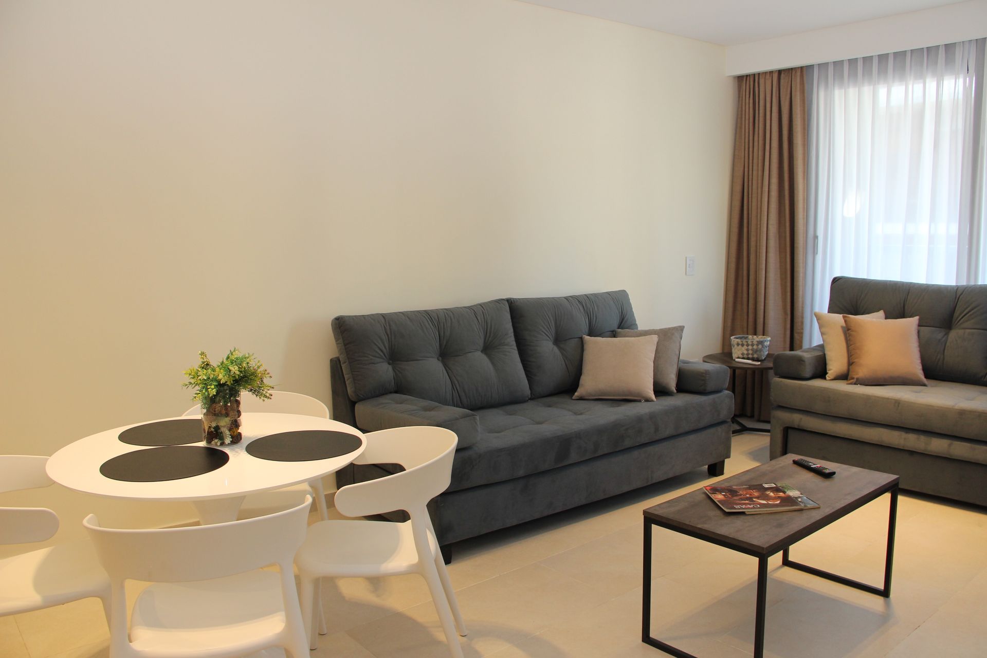 Una sala de estar con sofá, mesa y sillas.