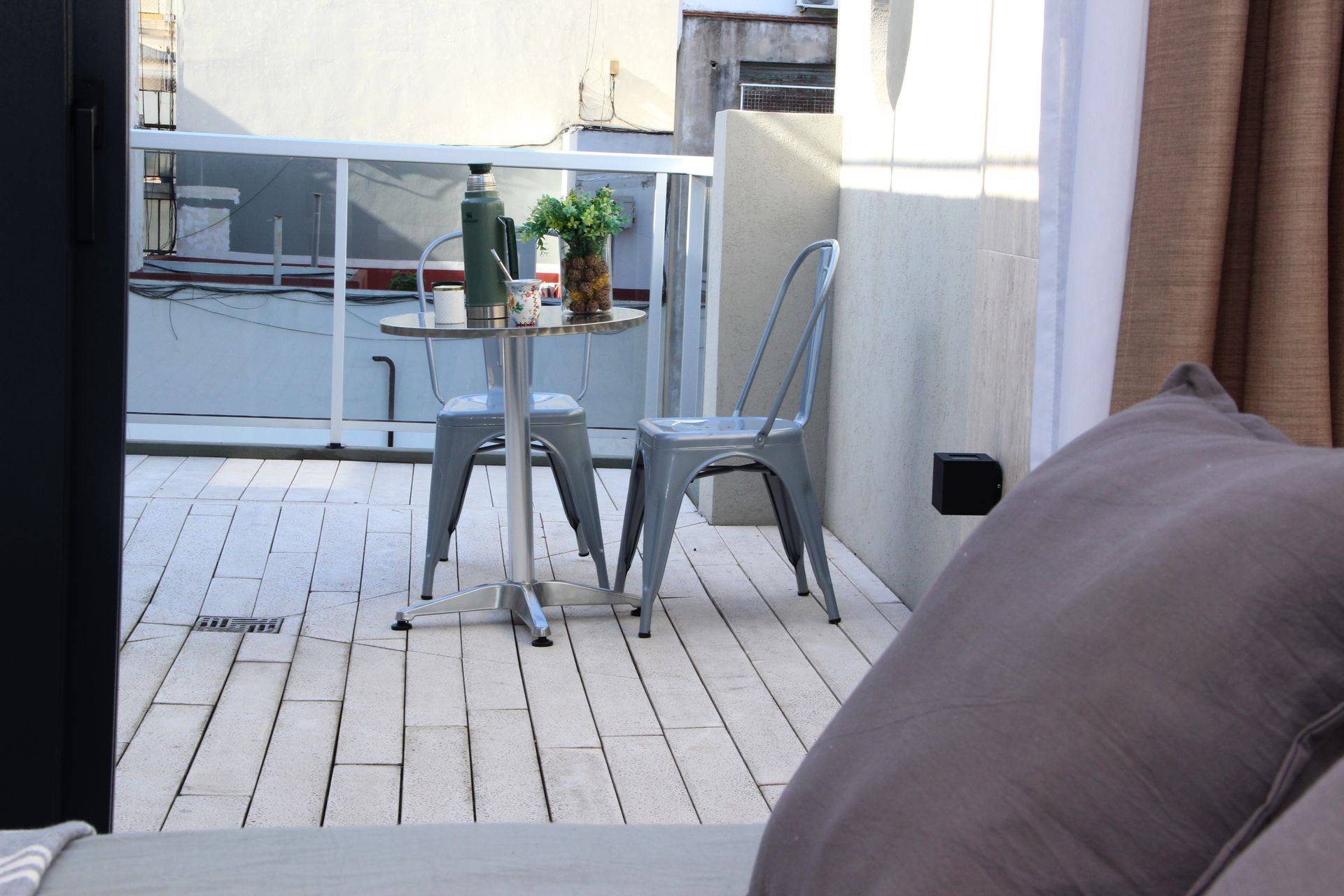 Un balcón con una mesa y sillas.