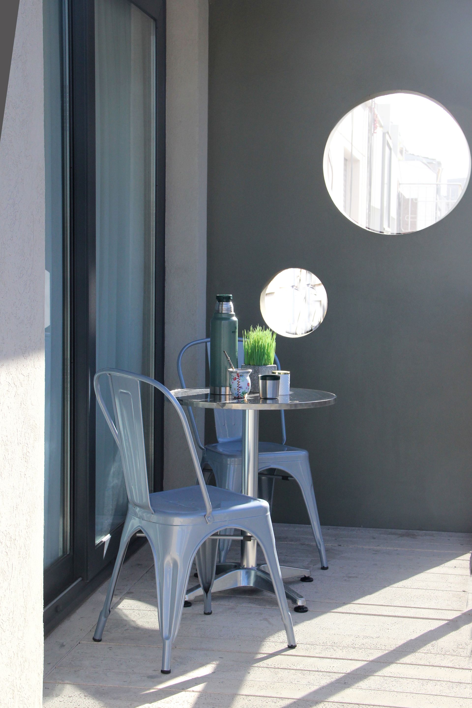 Hay una mesa y sillas en el balcón.