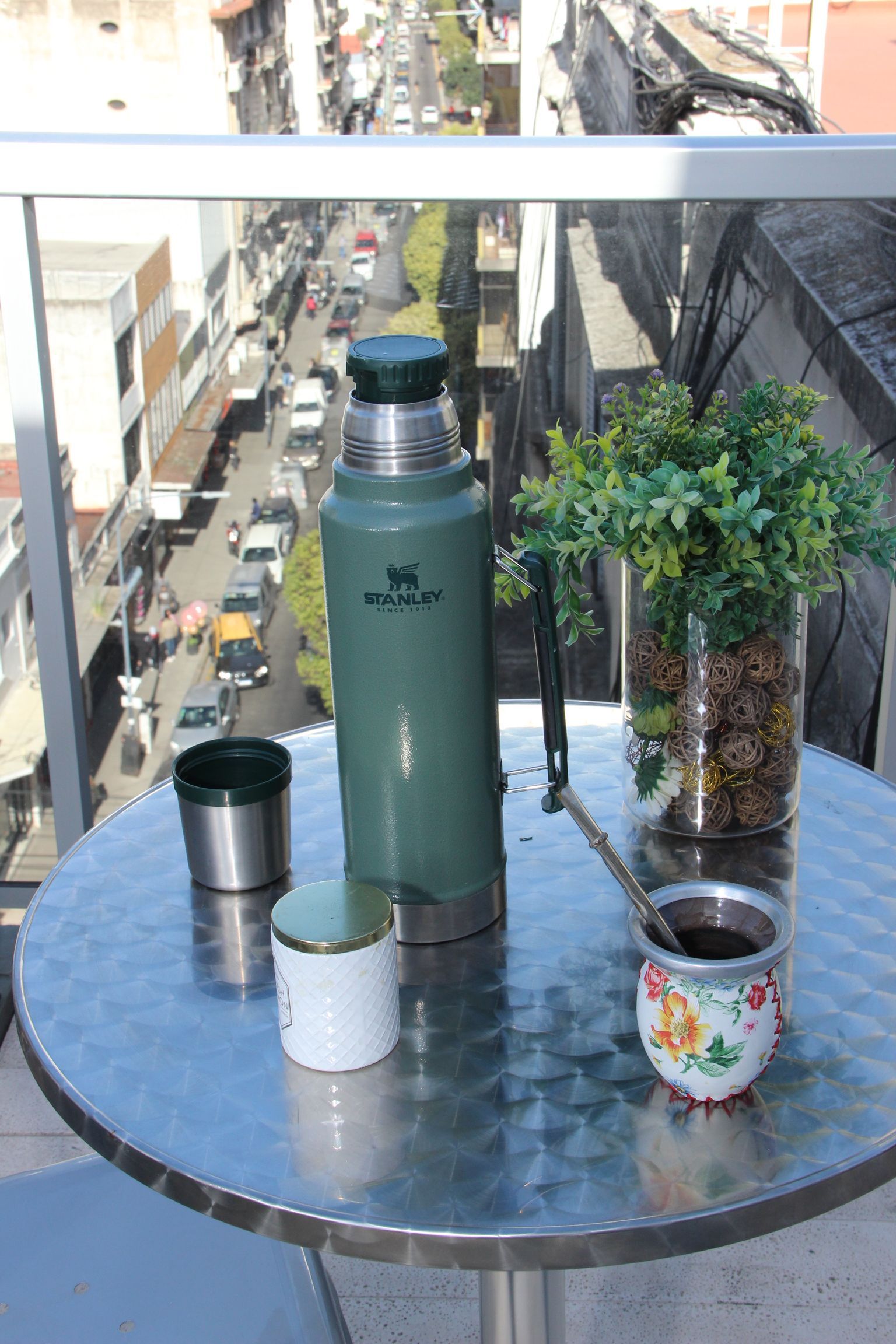 Una mesa con un termo y una taza de café encima.