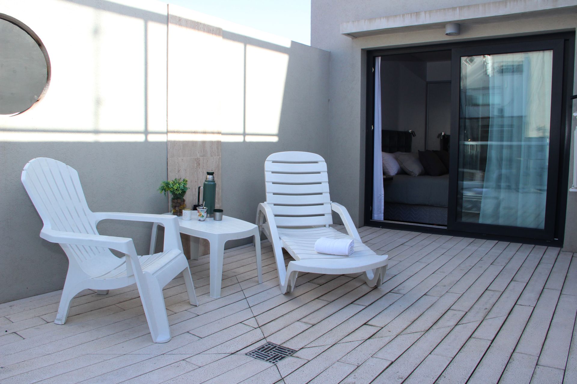 Hay dos sillas y una mesa en la terraza.