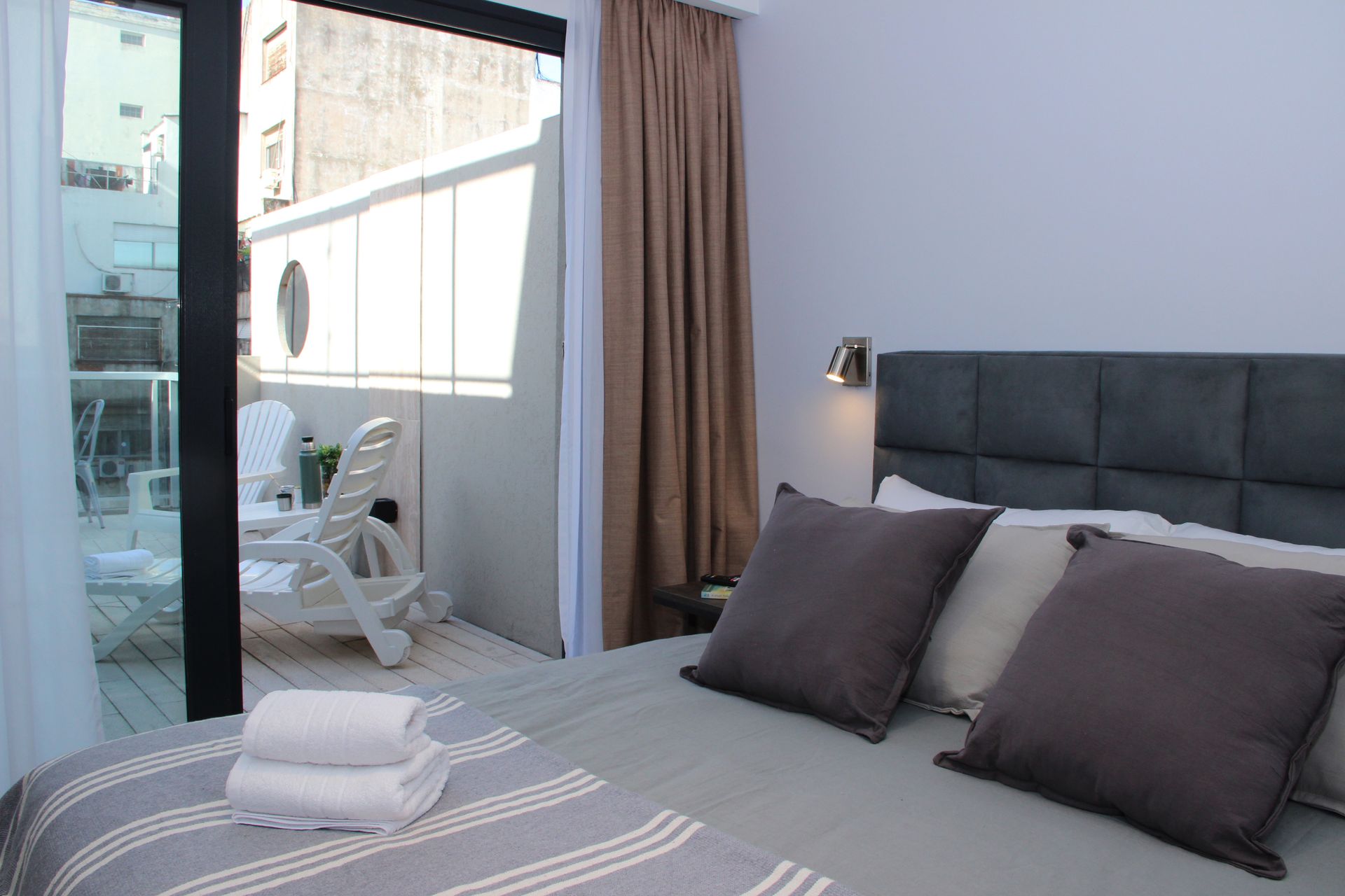 Un dormitorio con una cama grande y un balcón.