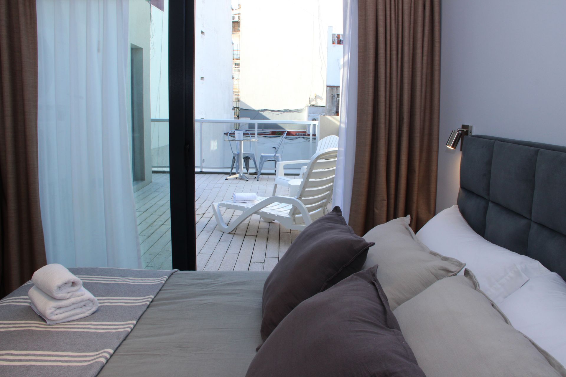 Un dormitorio con una cama grande y una puerta corrediza de vidrio que conduce a un balcón.