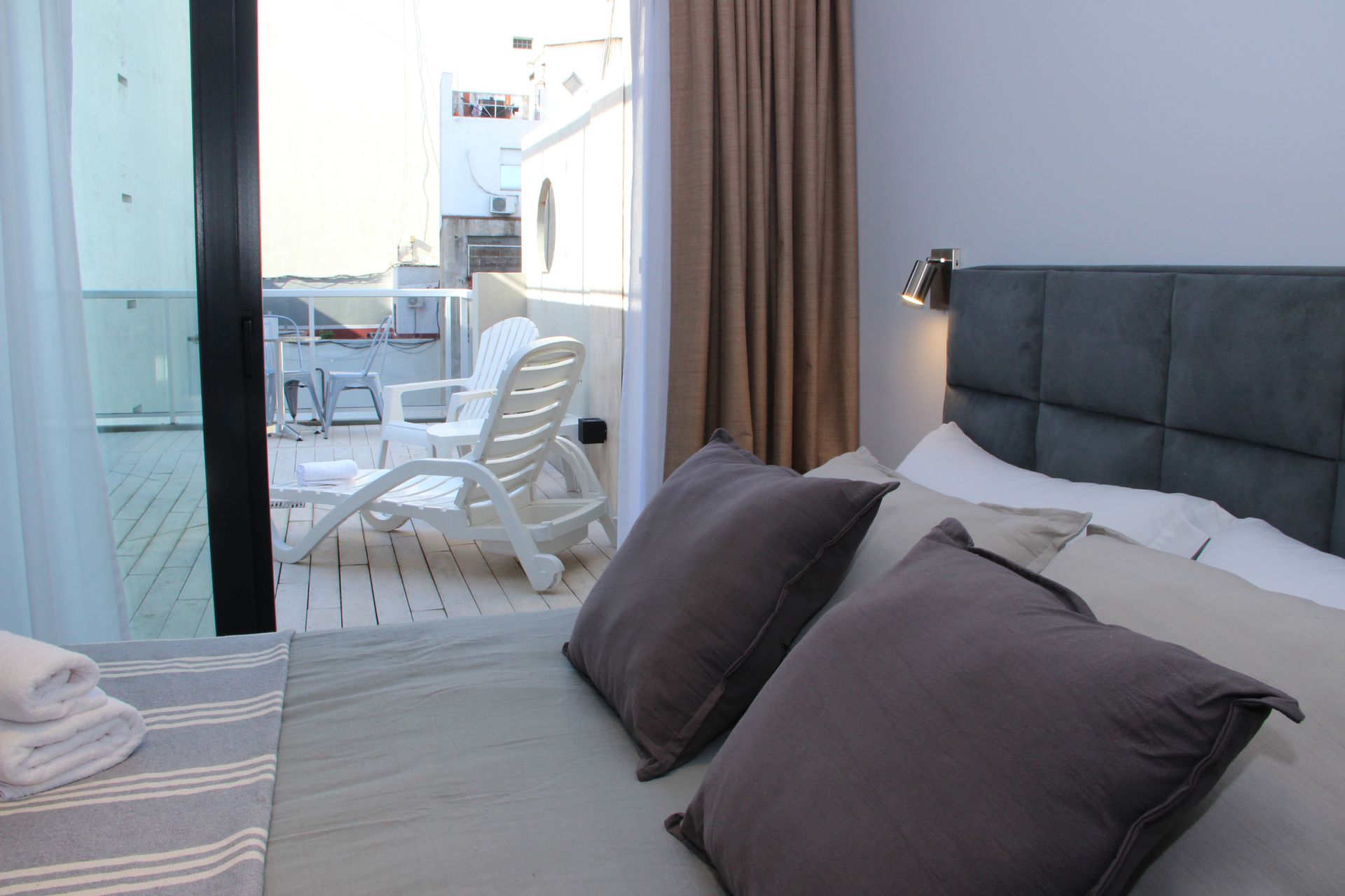 Un dormitorio con una cama, sillas y un balcón.