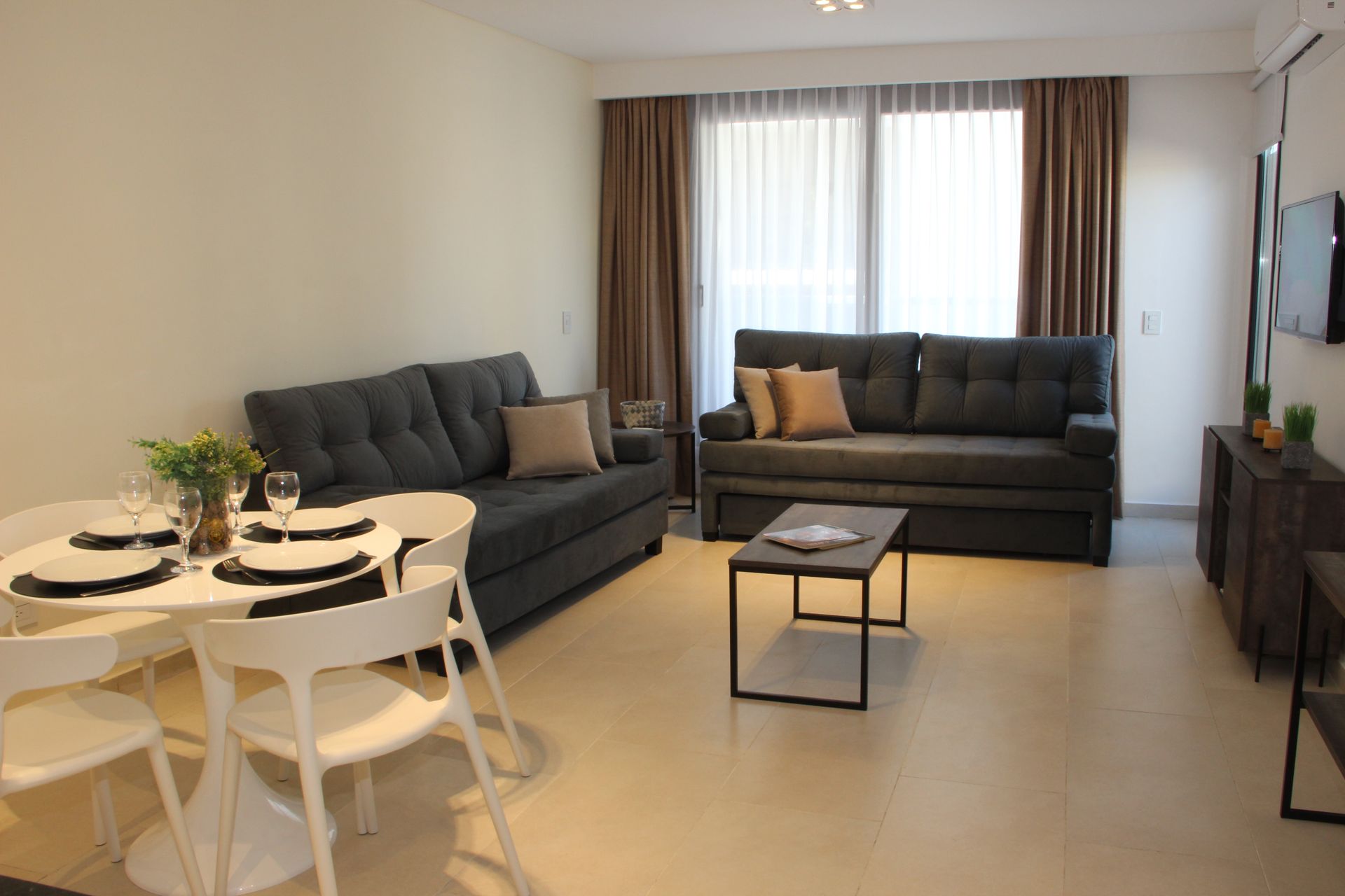 Una sala de estar con sofá, mesa y sillas.