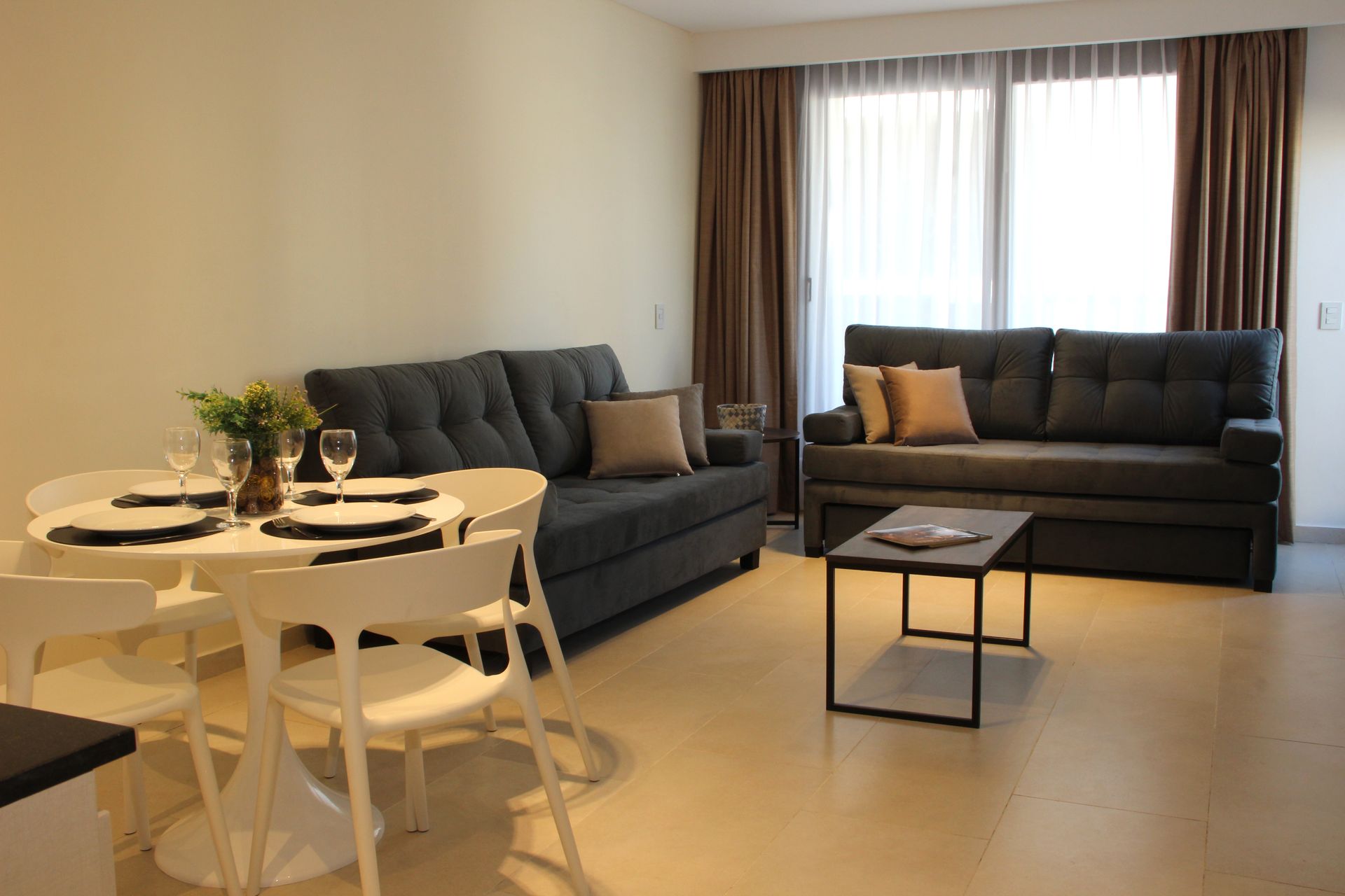 Una sala de estar con sofá, mesa y sillas.