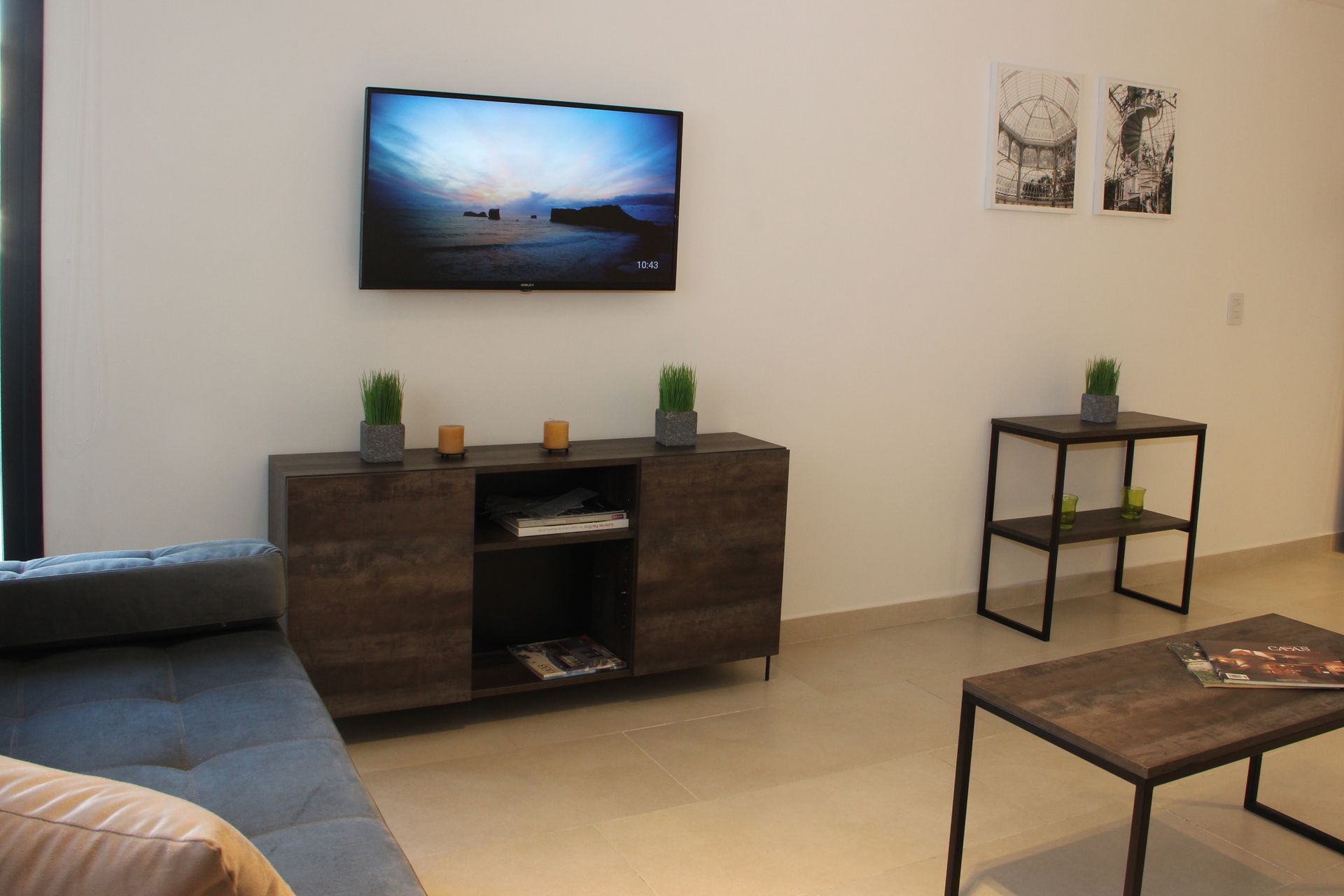 Una sala de estar con un televisor de pantalla plana en la pared.