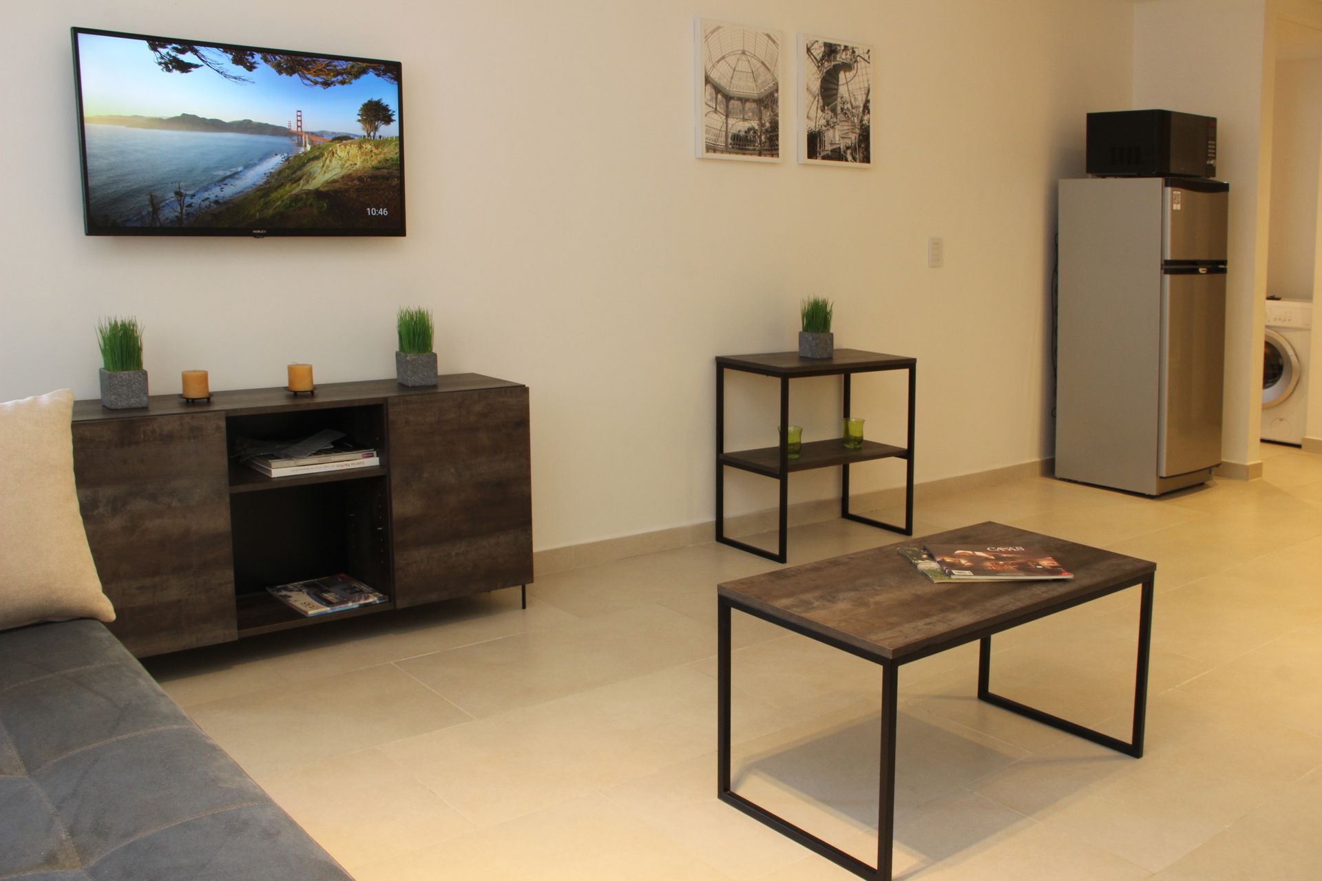 Una sala de estar con un sofá, una mesa de café y un televisor de pantalla plana.